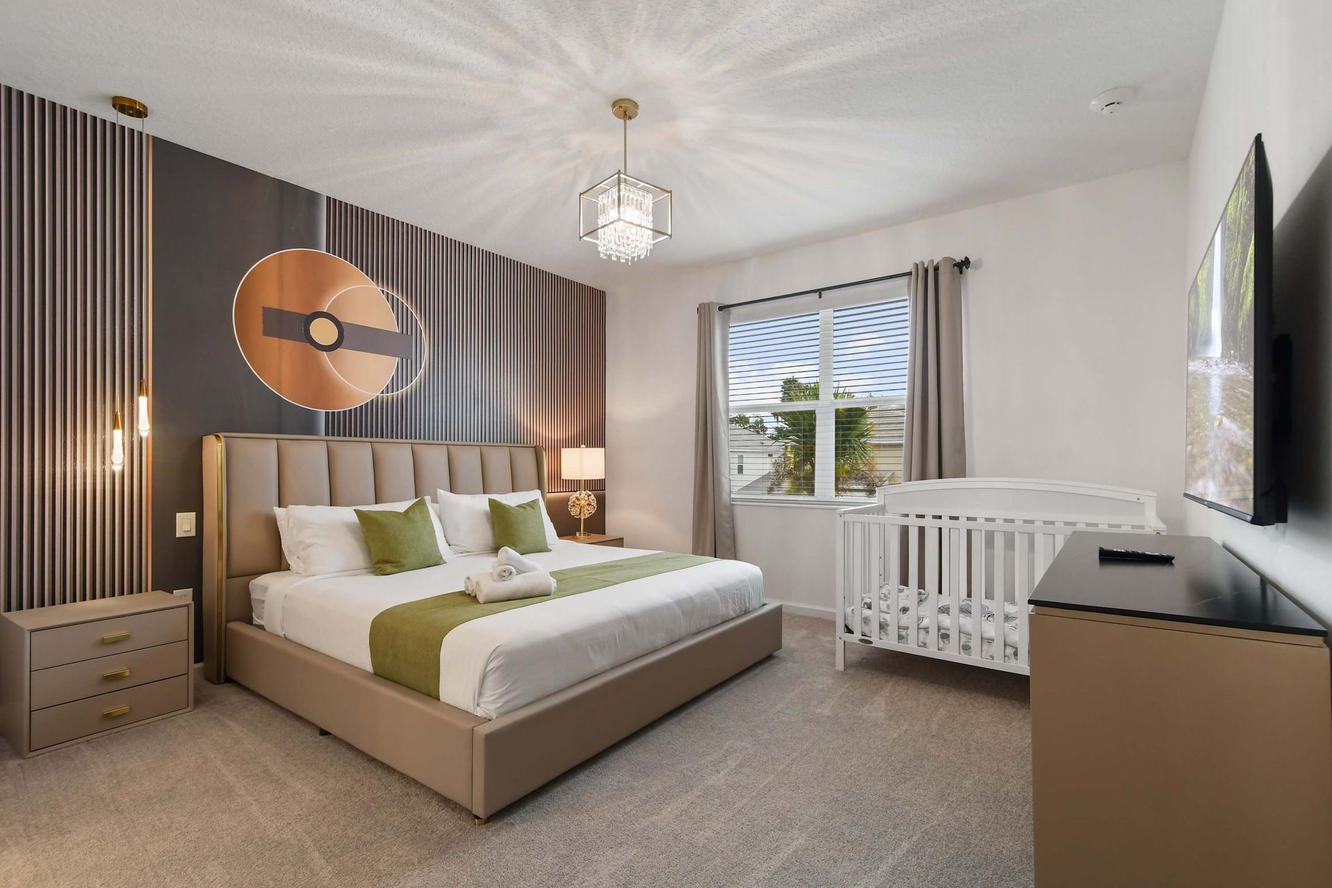 Stylish master bedroom with elegant decor, a cozy crib, and a modern accent wall.