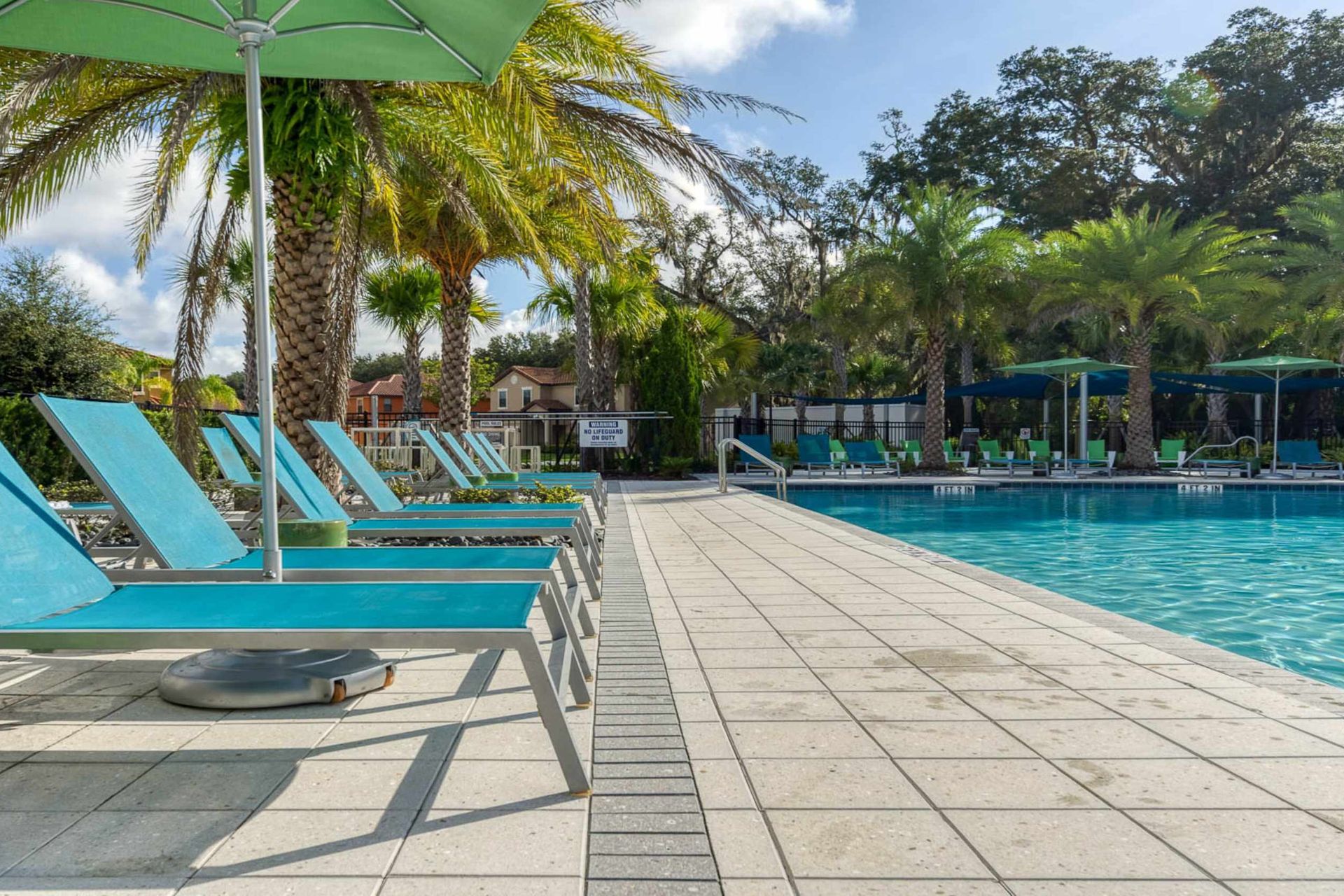 Relax in style with poolside loungers, lush palm trees, and a serene resort vibe