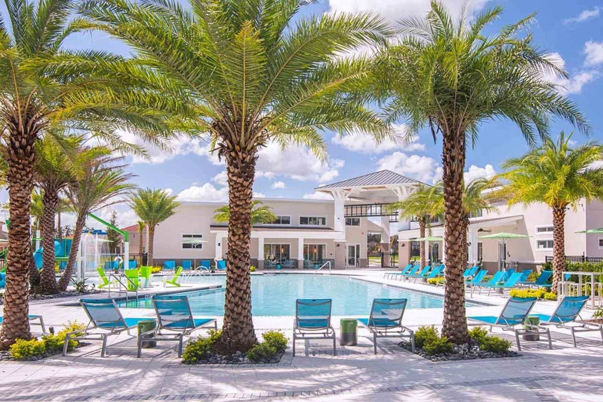 Luxury resort-style pool with palm trees, loungers, and a fun splash zone for all