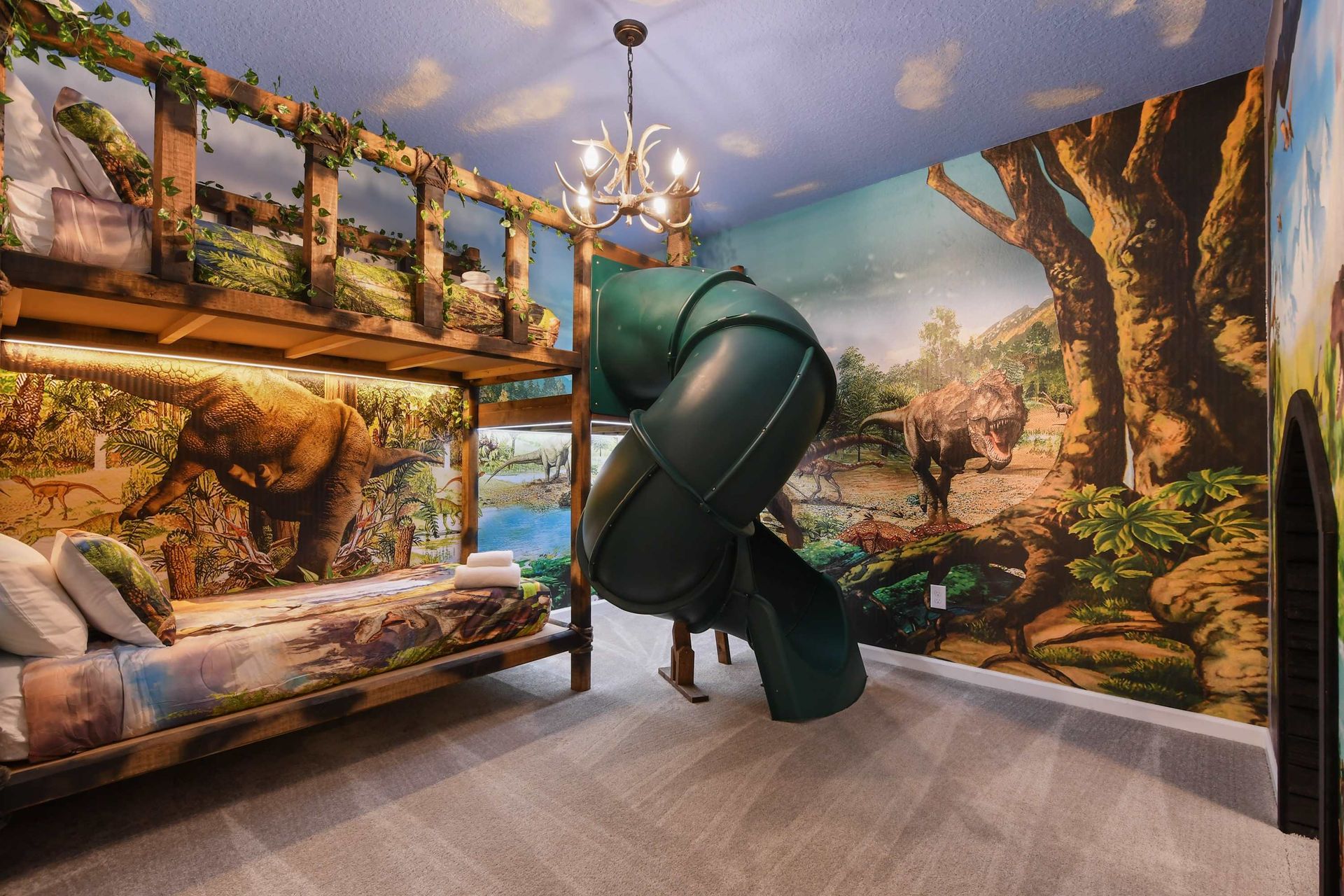 Epic dinosaur-themed bedroom with jungle murals, a bunk bed, and an indoor slide.
