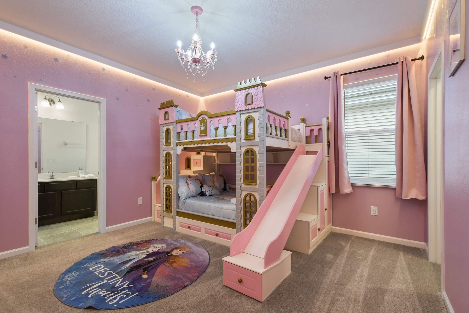 Princess-themed bedroom with a castle bunk bed, slide, and magical pink decor.