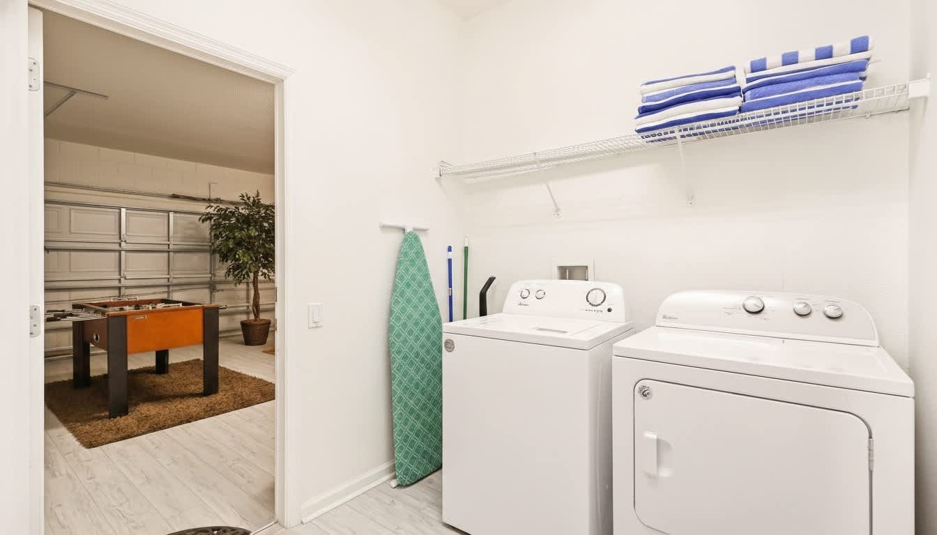 Convenient laundry room with a washer, dryer, and extra towels, plus game room access.
