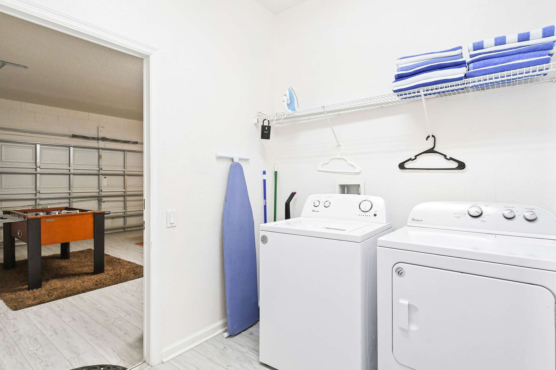 Convenient laundry room with a washer, dryer, and extra towels, plus game room access.