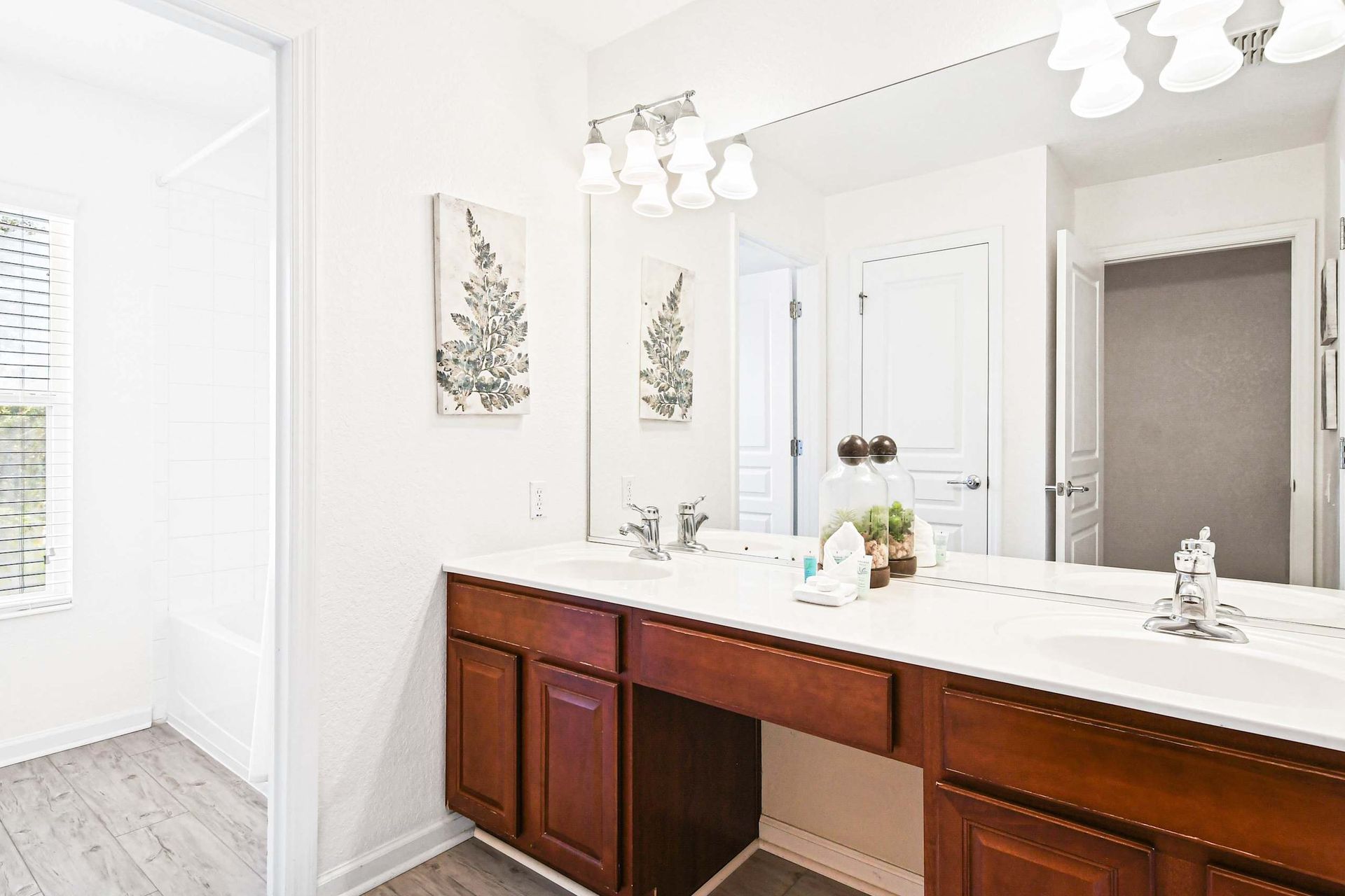 Bright and stylish bathroom with a dual vanity, elegant decor, and plenty of natural light.