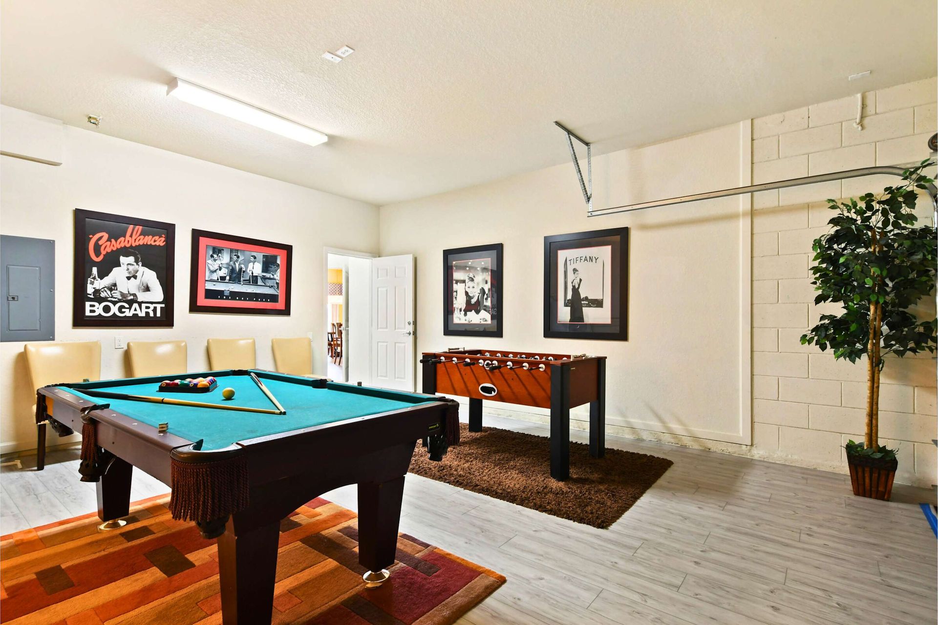 Stylish game room with a pool table, foosball, and classic movie-themed decor.