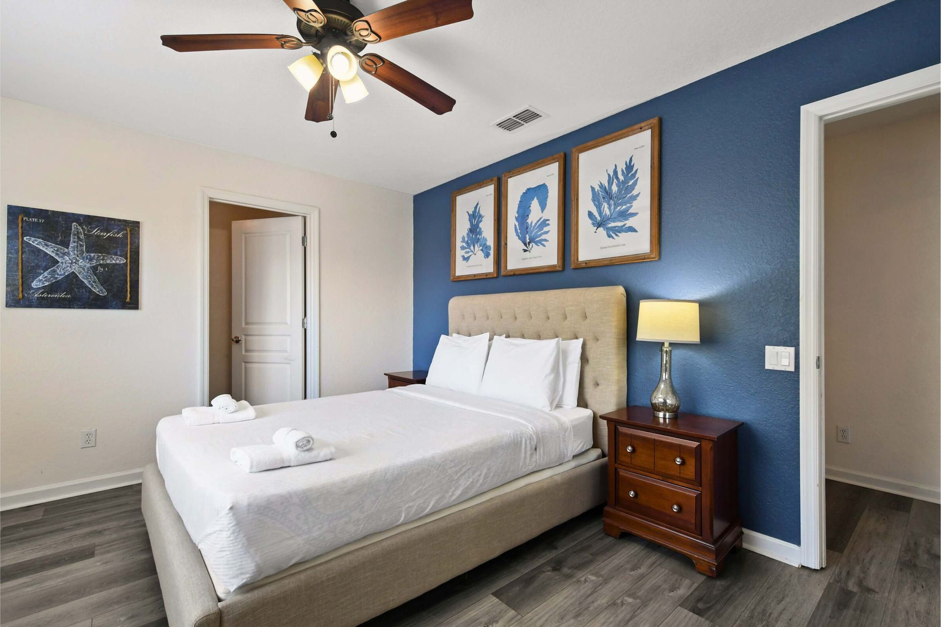 Coastal-inspired bedroom with a plush bed, elegant decor, and a serene atmosphere.