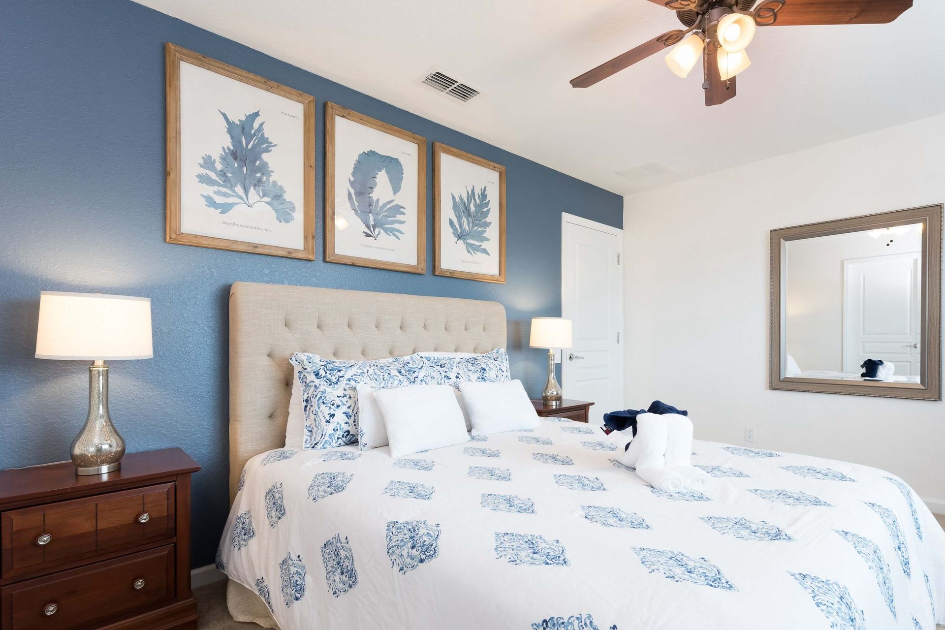 Elegant coastal-themed bedroom with a plush bed, calming blue tones, and stylish decor.