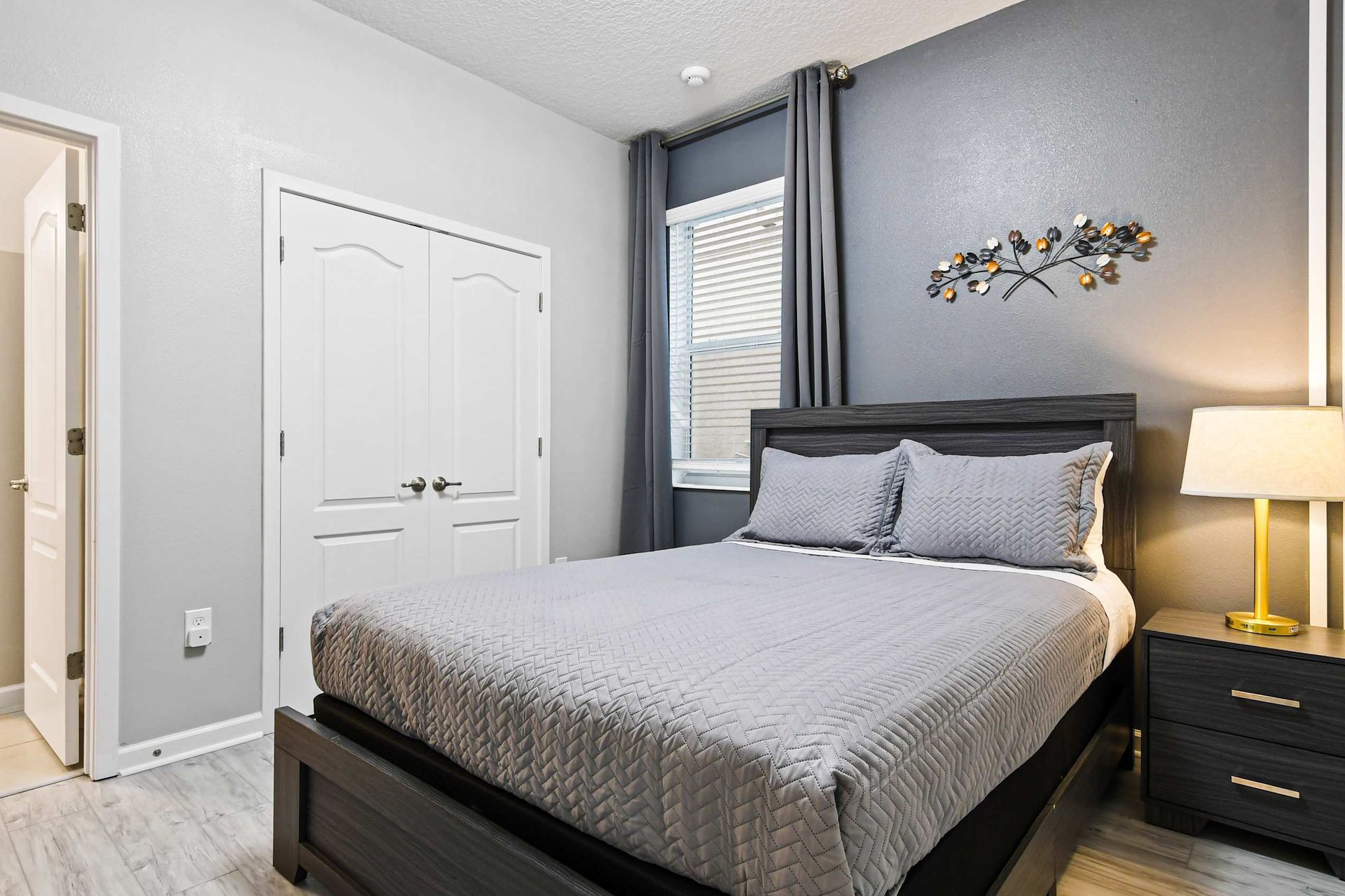 Modern bedroom with sleek furnishings, soft lighting, and an ensuite bathroom.