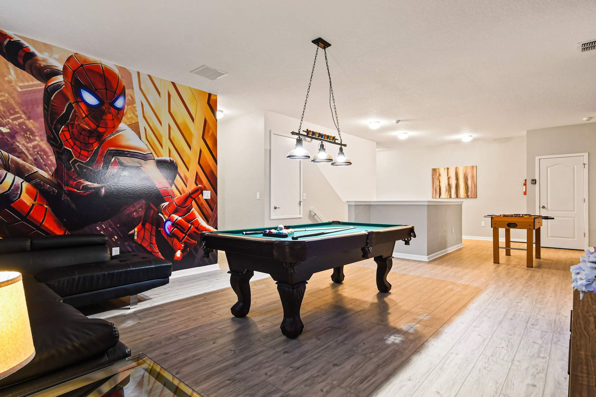 Superhero-themed game room with pool table, foosball, and vibrant wall art!