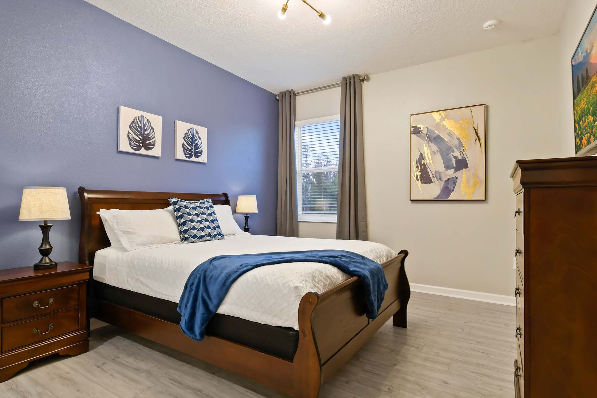 Minimalist bedroom, shades for peaceful sleep and TV for entertainment.