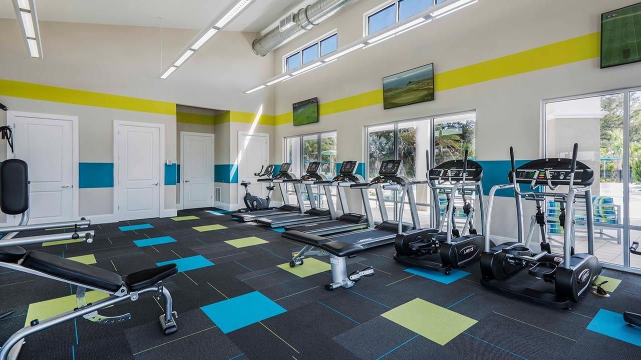 Bright, modern fitness center with treadmills, ellipticals, and vibrant decor.