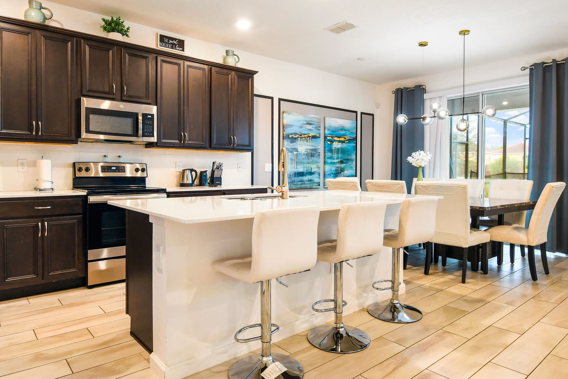 Stylish modern kitchen with sleek dark cabinets, a spacious island, and elegant dining.
