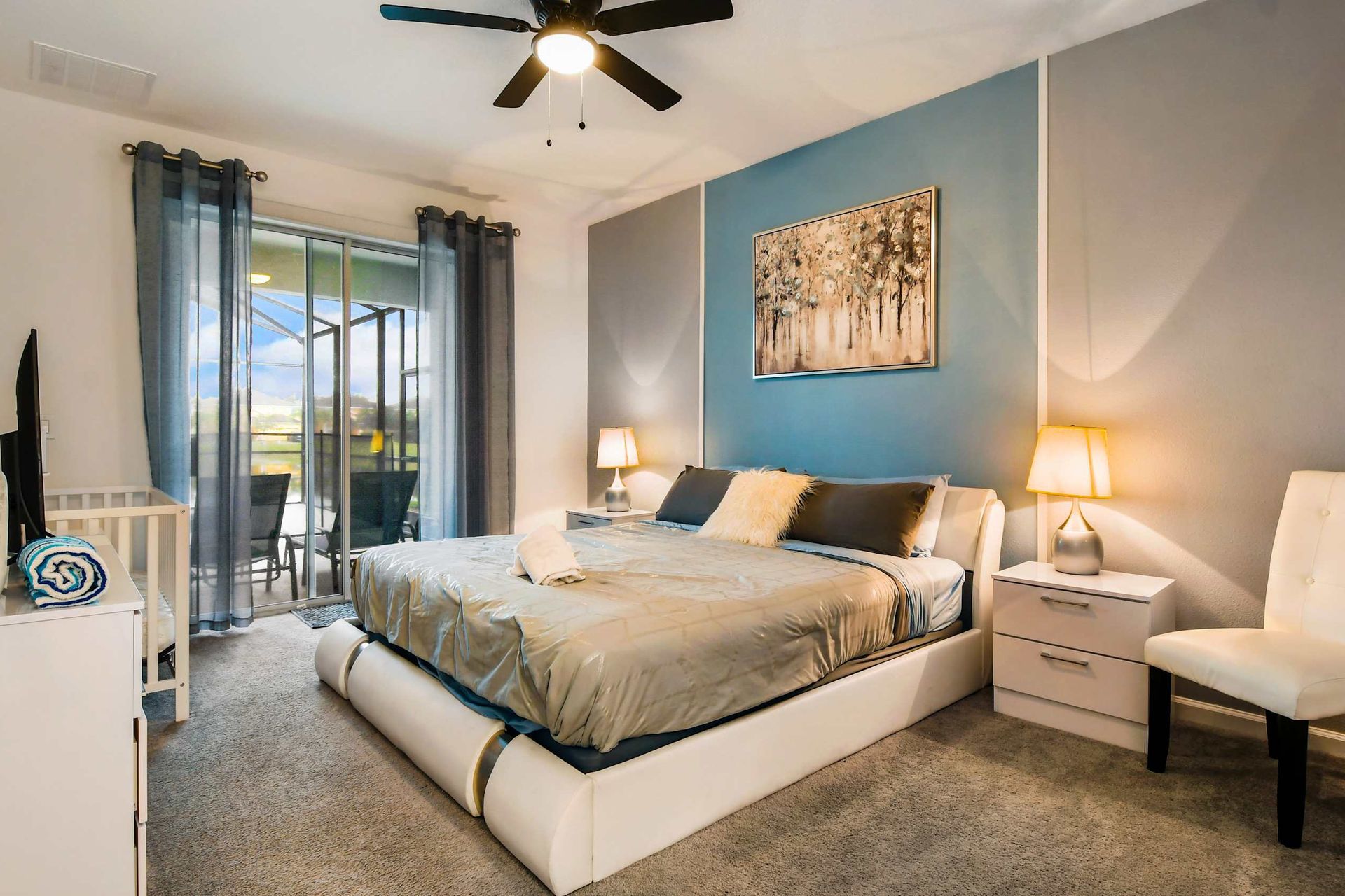 The master bedroom features a luxuriously large king bed with a crib