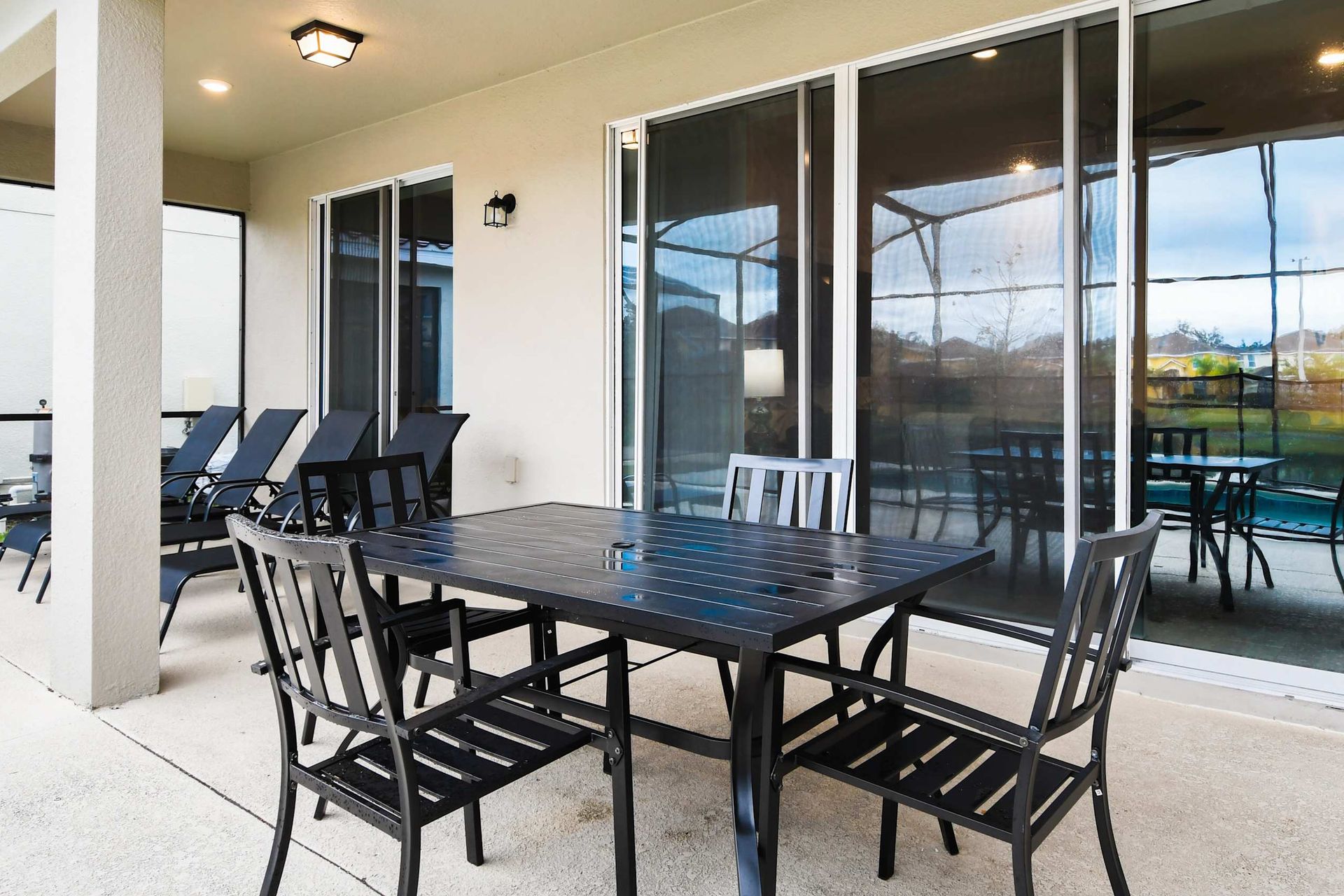 Relaxing screened-in patio with outdoor dining, lounge chairs, and peaceful lake views.