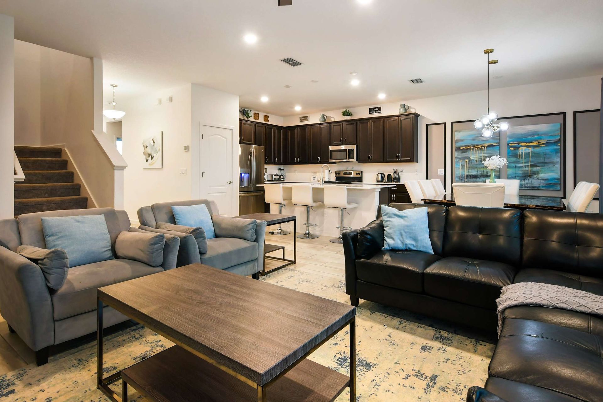 Spacious open-concept home with modern decor, cozy seating, and a full kitchen.