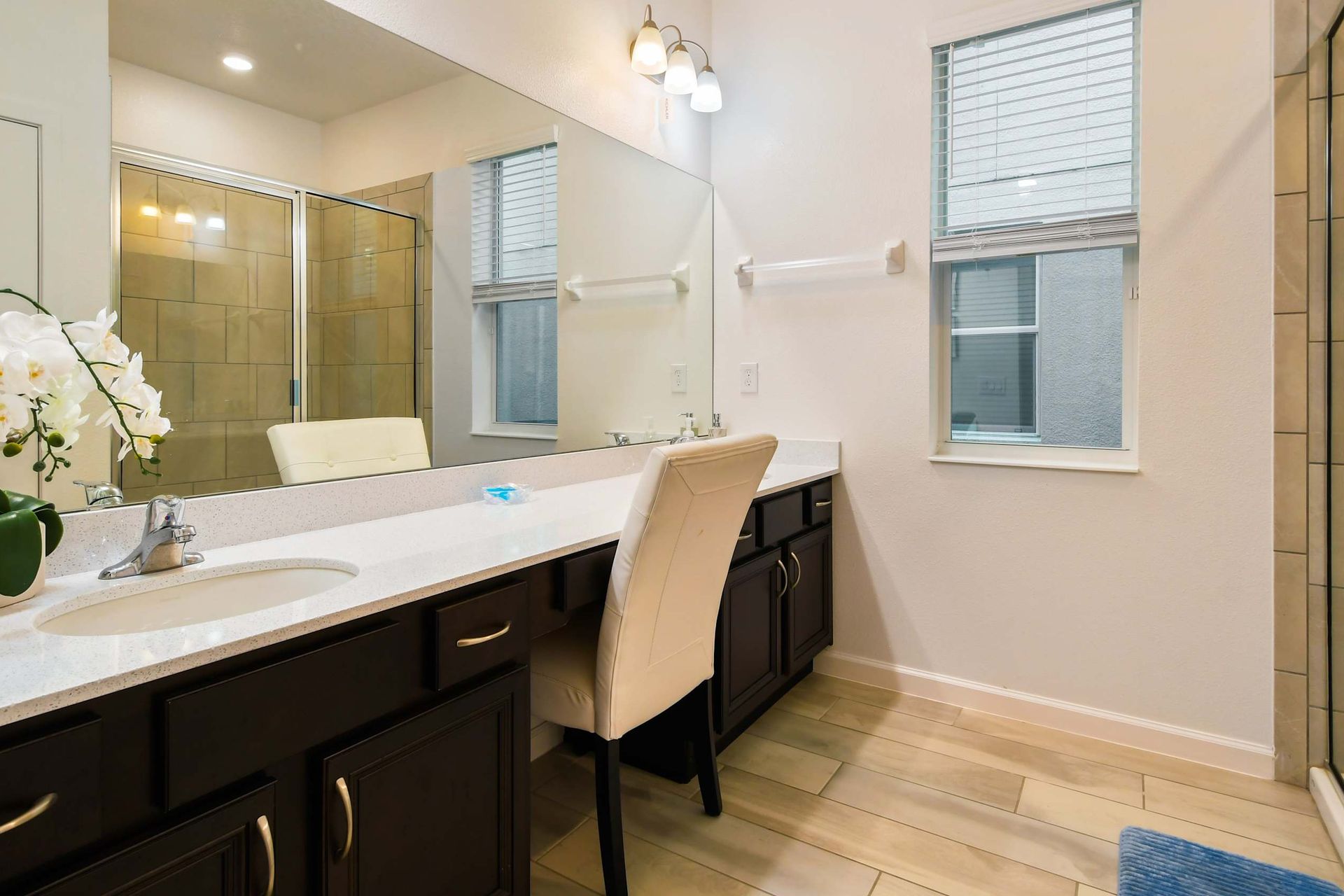 Elegant bathroom with dual sinks, walk-in shower, and modern lighting. Relax here!