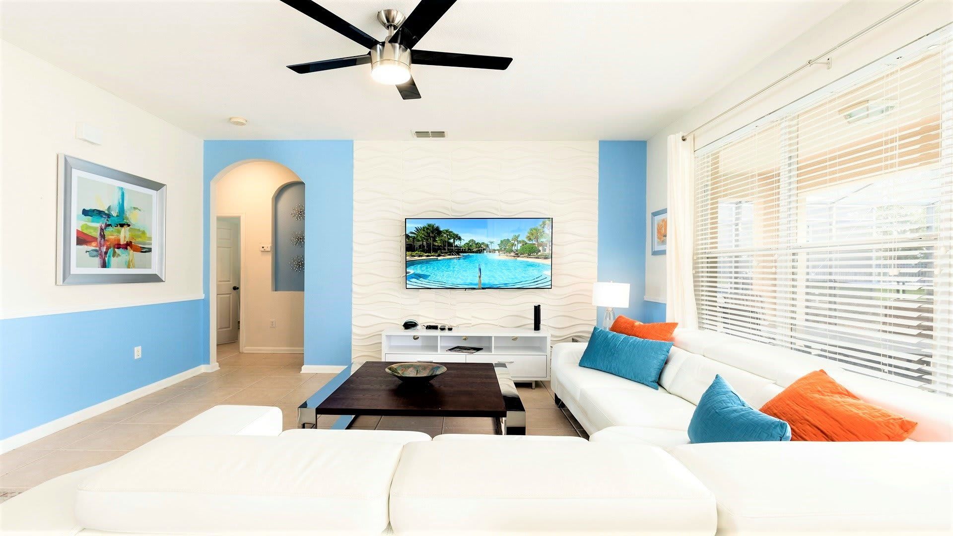 Modern, vibrant living room with a sleek design, cozy seating, and a big TV!