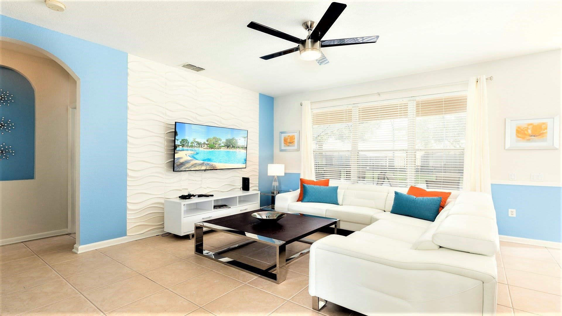 Modern, vibrant living room with a sleek design, cozy seating, and a big TV!