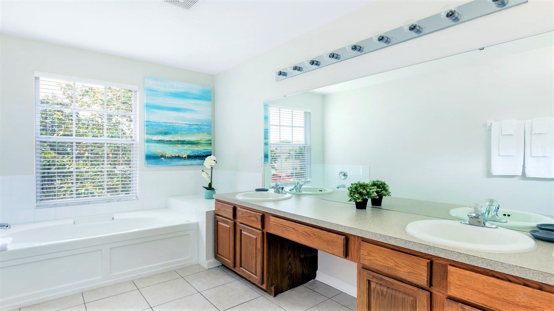 Bright and spacious bathroom with a soaking tub, dual sinks, and natural light.