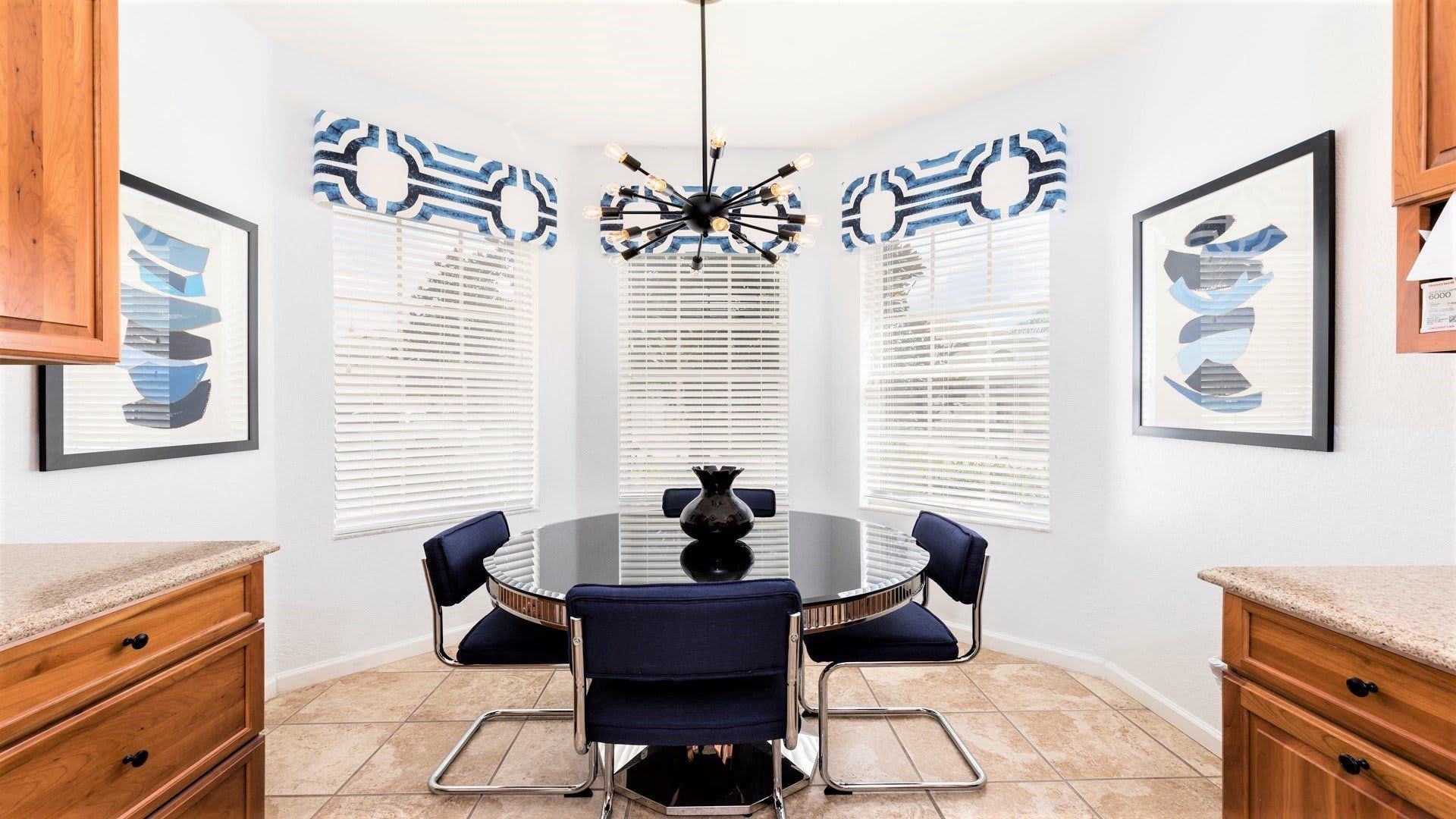Stylish dining nook with modern decor, bold lighting, and a sleek glass table.