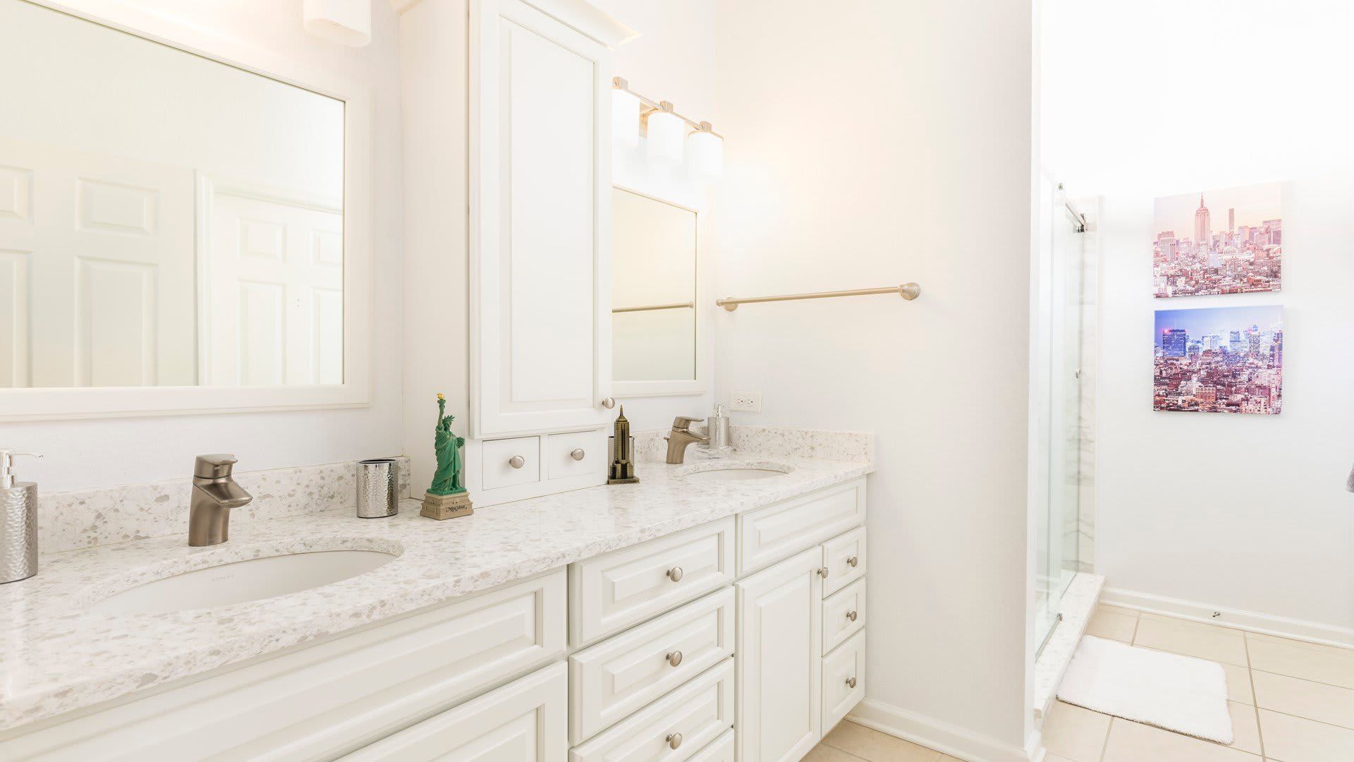 Bright and elegant bathroom with dual sinks, a spacious shower, and modern touches.