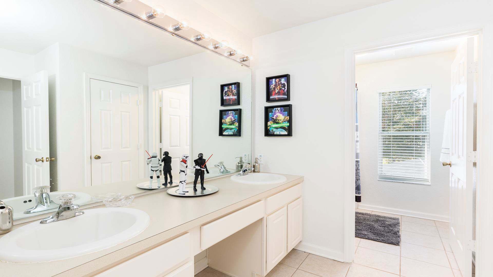 Star Wars-themed bathroom with double sinks, bright lighting, and fun décor