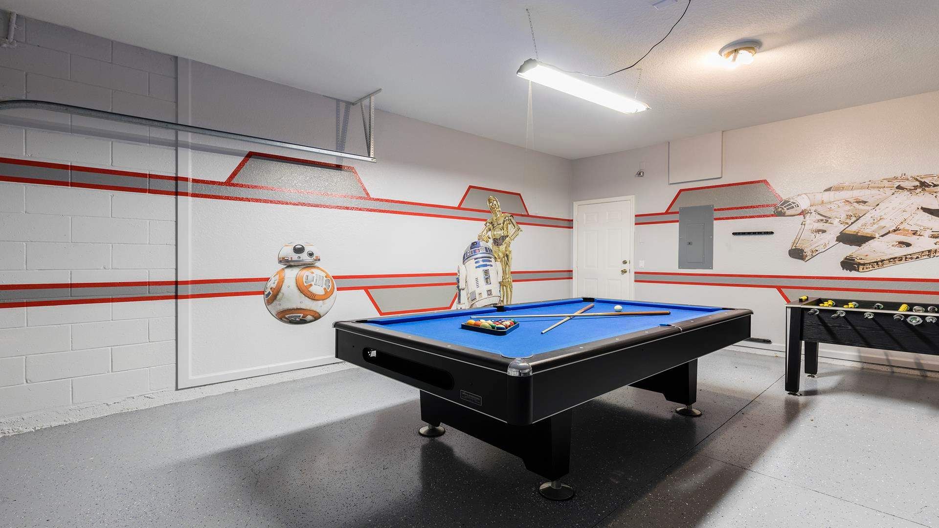 Star Wars-themed game room with pool table, foosball, and epic wall murals.