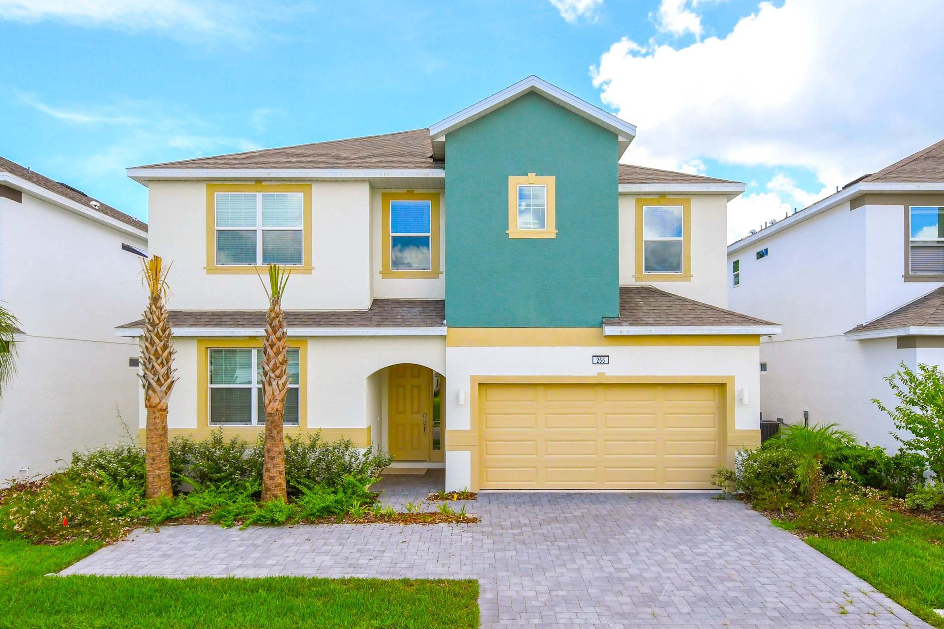 Spacious modern home with vibrant curb appeal, lush landscaping, and a two-car garage.