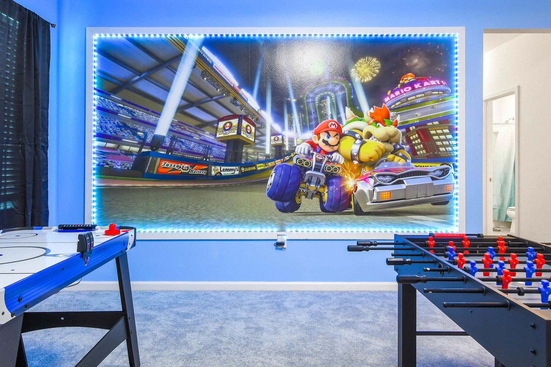 Ultimate game room with air hockey, foosball, and a Mario Kart-themed wall.