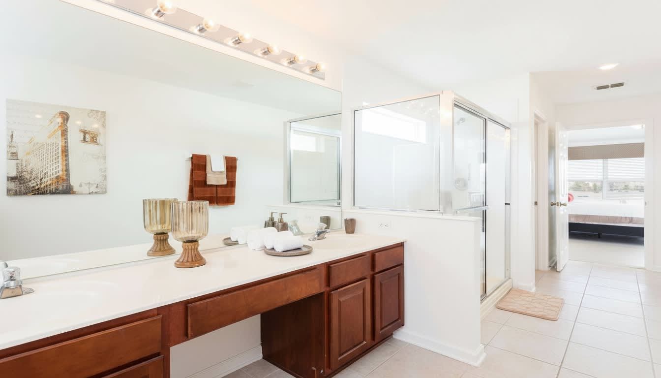 Bright and spacious master bathroom with dual sinks, a glass-enclosed shower, and luxe decor.