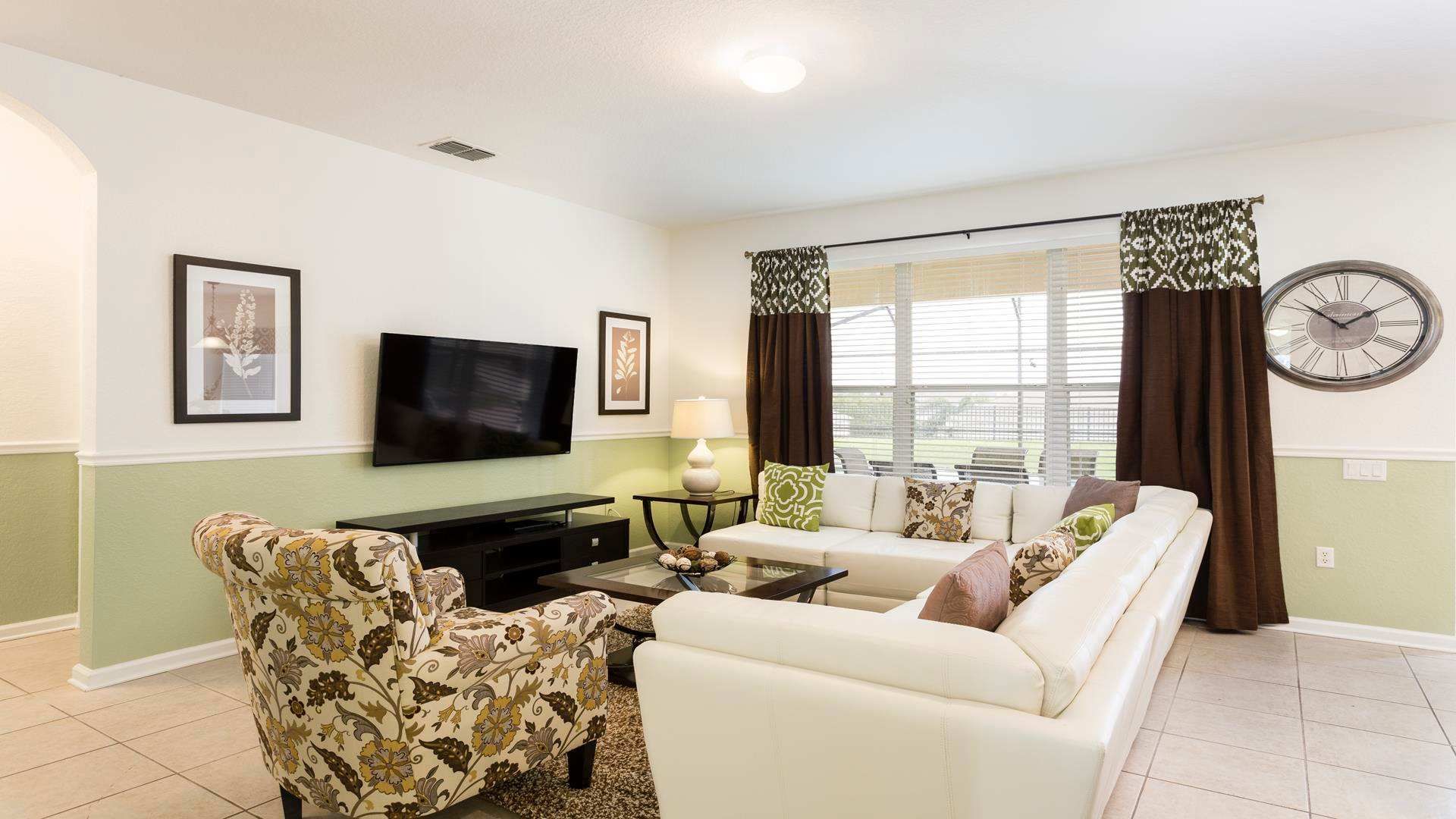 Stylish and cozy living room with ample seating, natural light, and a smart TV.