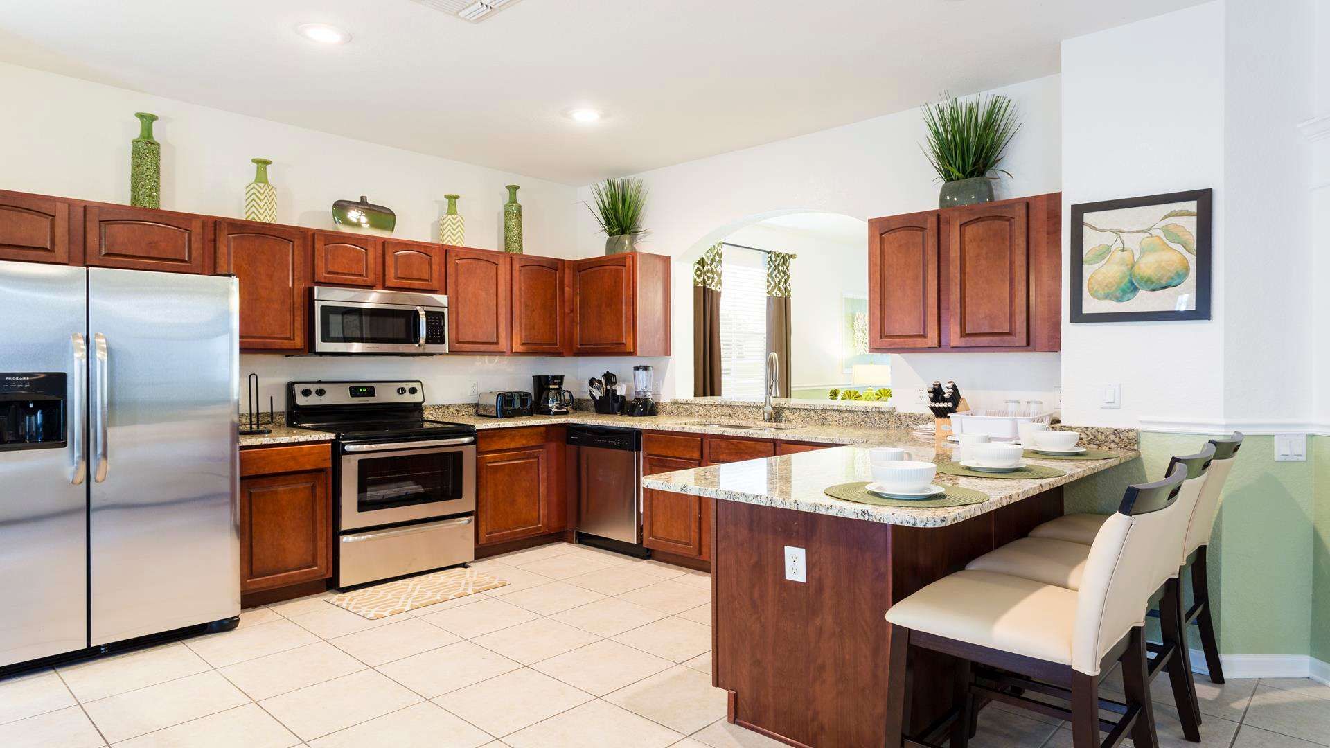 Spacious gourmet kitchen with granite countertops, stainless steel appliances, and bar seating.