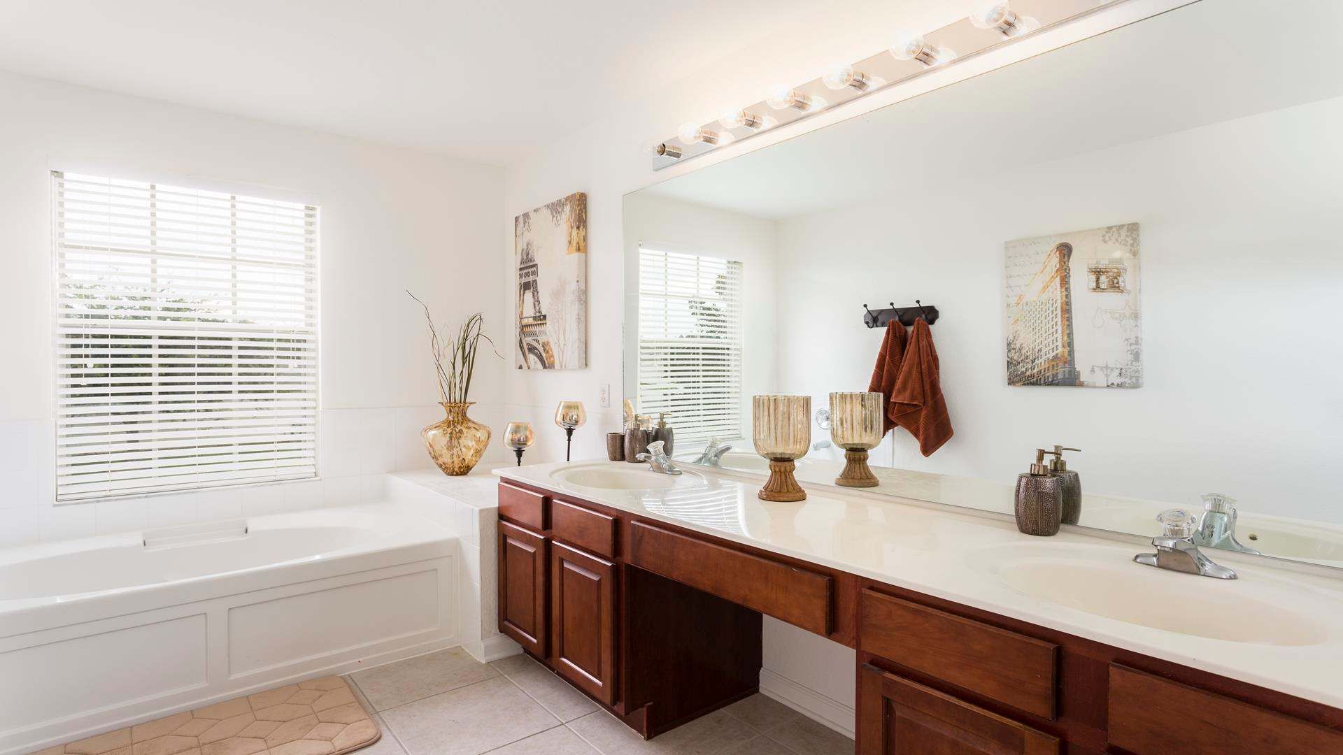 Spacious master bathroom with dual sinks, a soaking tub, and elegant decor.