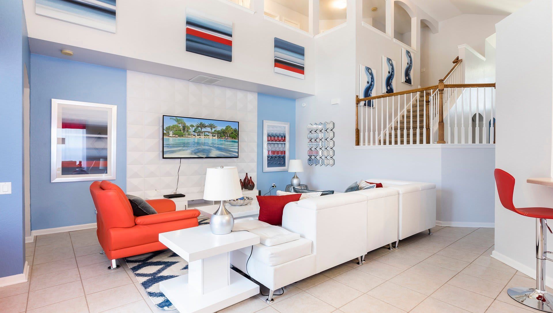 Movie night ready! This living room features a comfy couch, a mounted TV, and colorful chairs for movie marathons or game nights.