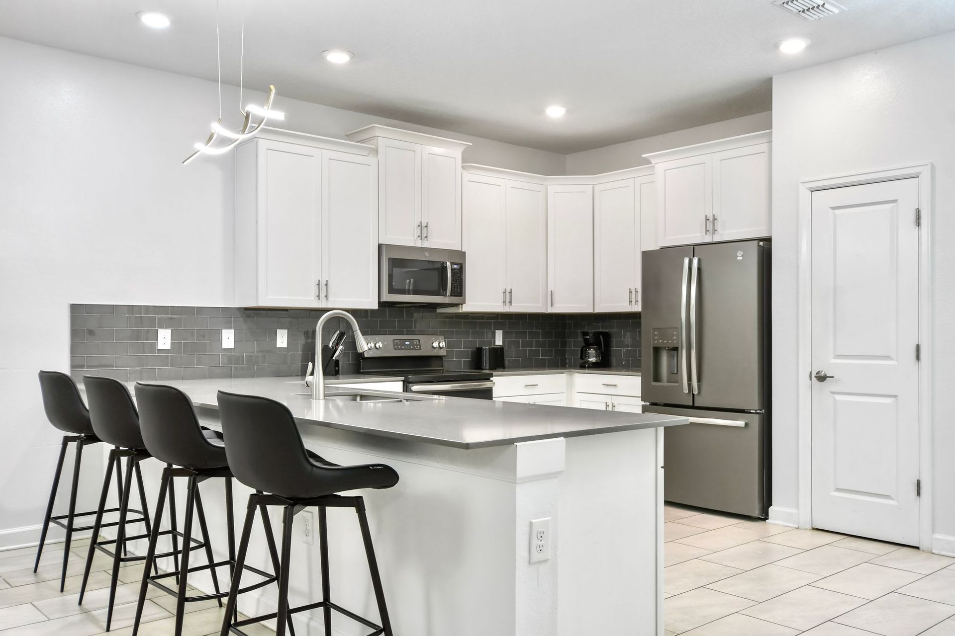 Sleek modern kitchen with stainless steel appliances, stylish bar seating, and elegance.