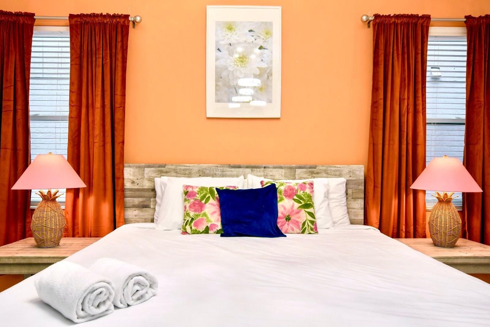 Vibrant tropical-inspired bedroom with warm tones, rustic wood accents, and cozy decor.