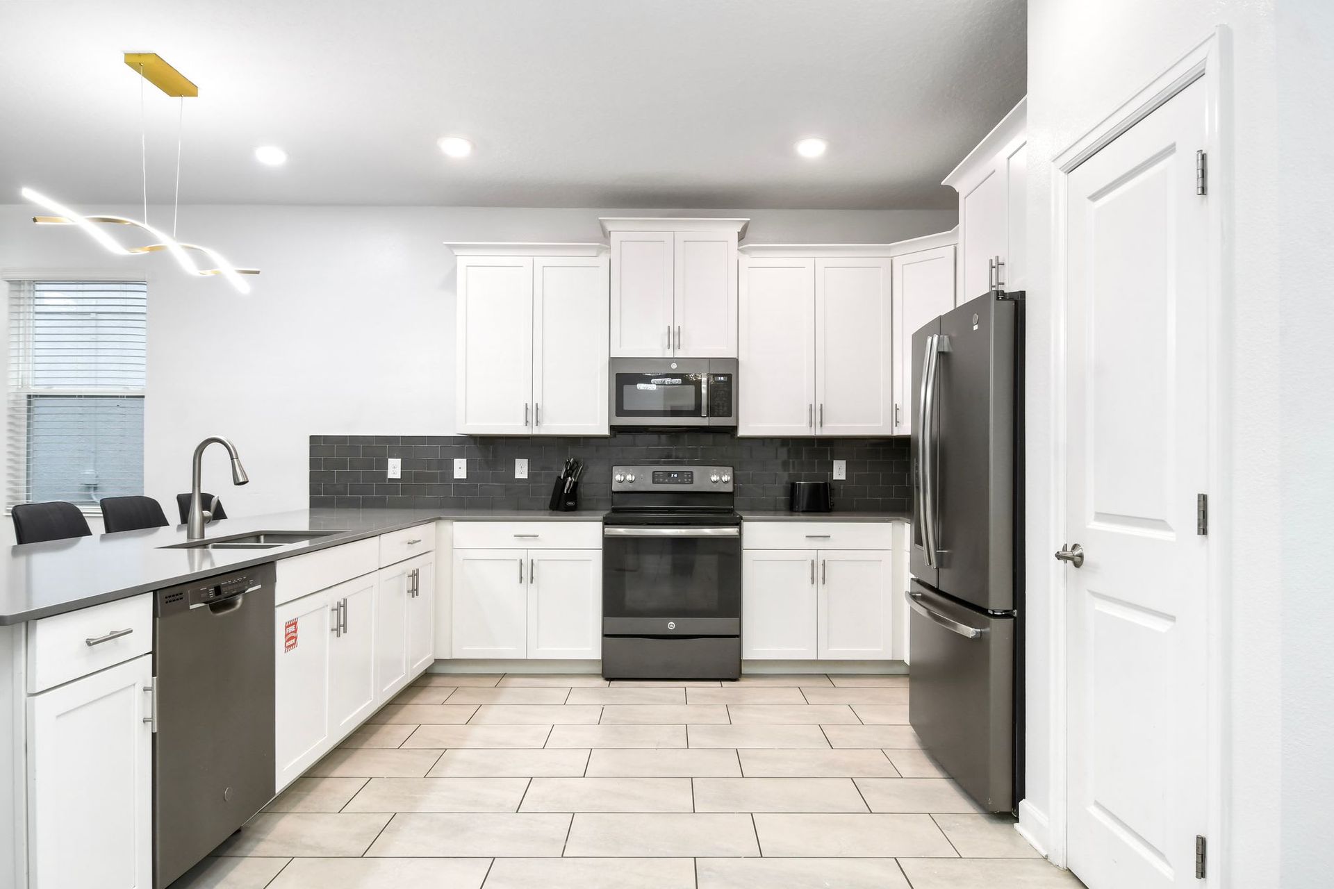 Modern kitchen with sleek stainless steel appliances, white cabinetry, and stylish design.
