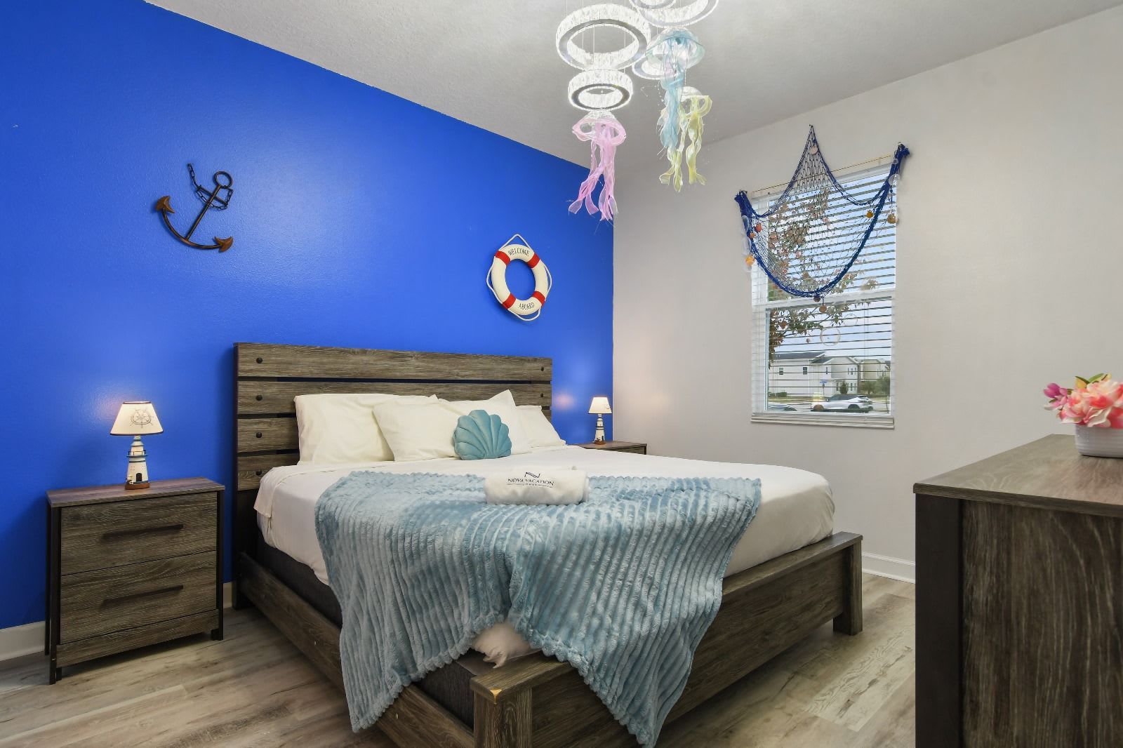 A charming nautical-themed bedroom with deep blue and white walls, maritime décor, and cozy coastal-inspired accents. 