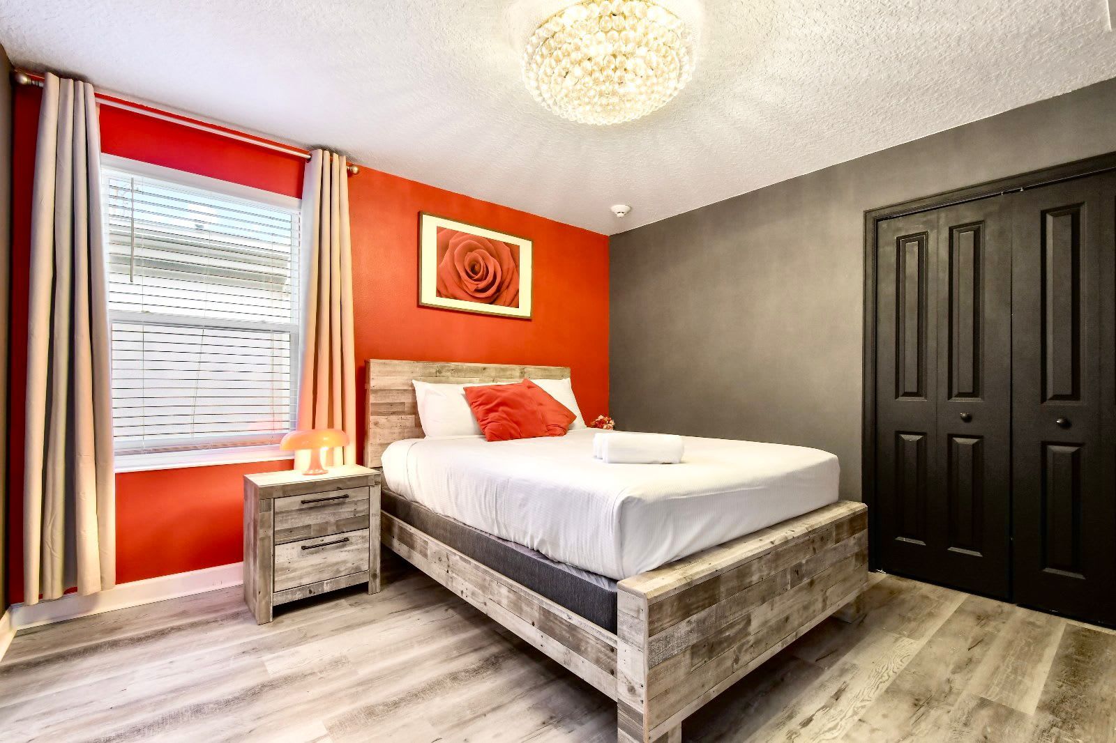 Bold and elegant bedroom featuring a striking red and black color scheme, rustic wooden furniture, and a cozy ambiance.