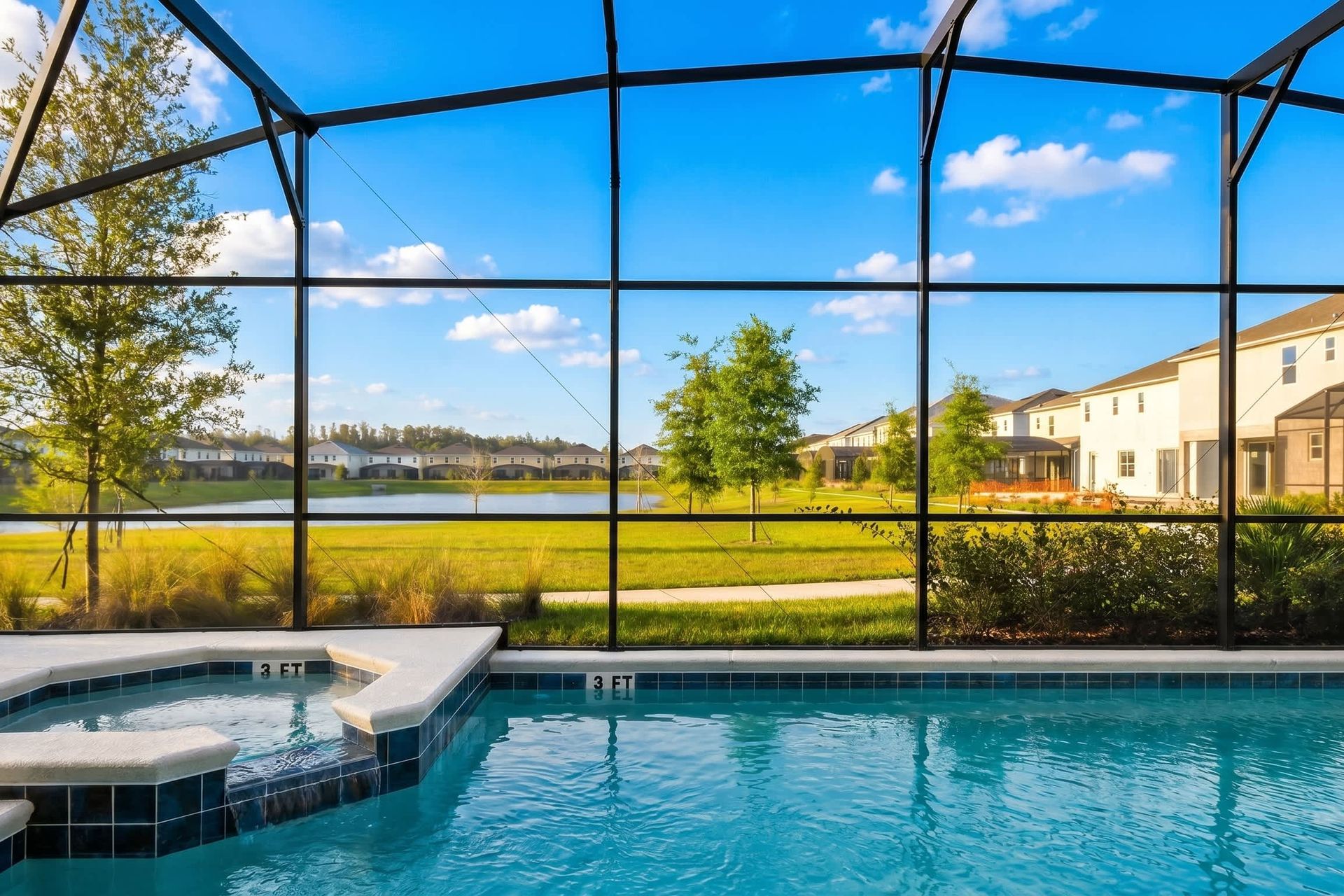 Spacious screened-in pool area with spa, lounge chairs, and outdoor seating.
