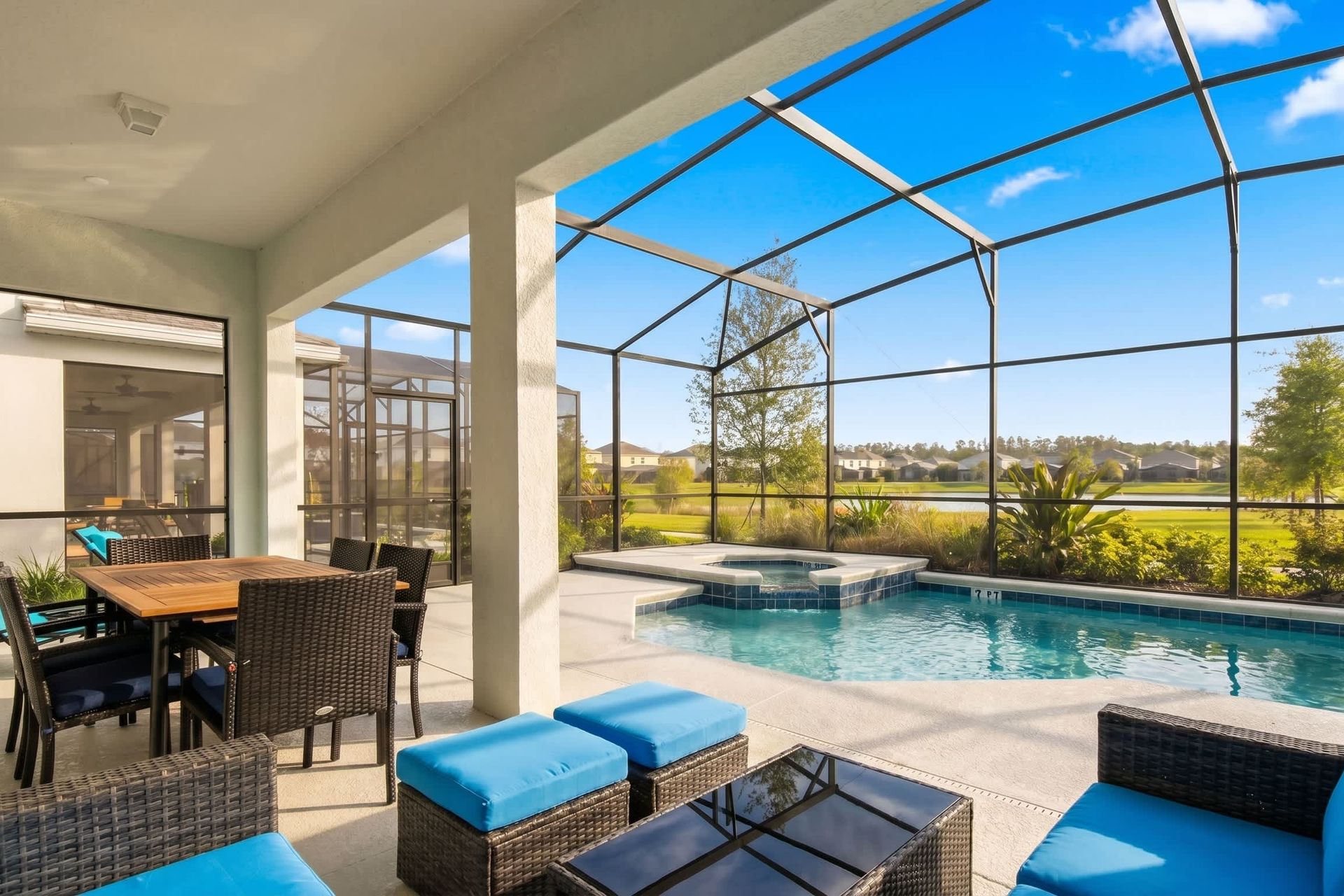 Relax on the covered patio with cozy seating and a dining area by the pool.