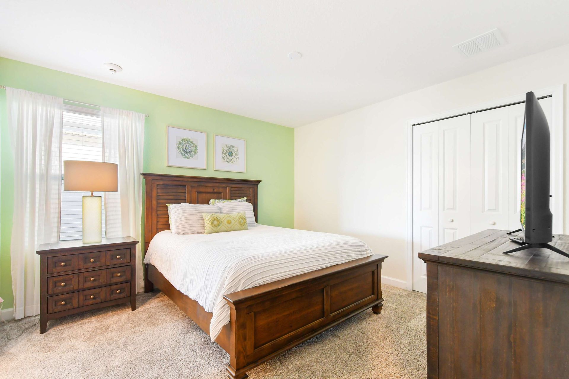 Tranquil bedroom with rich wood furnishings, soft green accents, and cozy charm