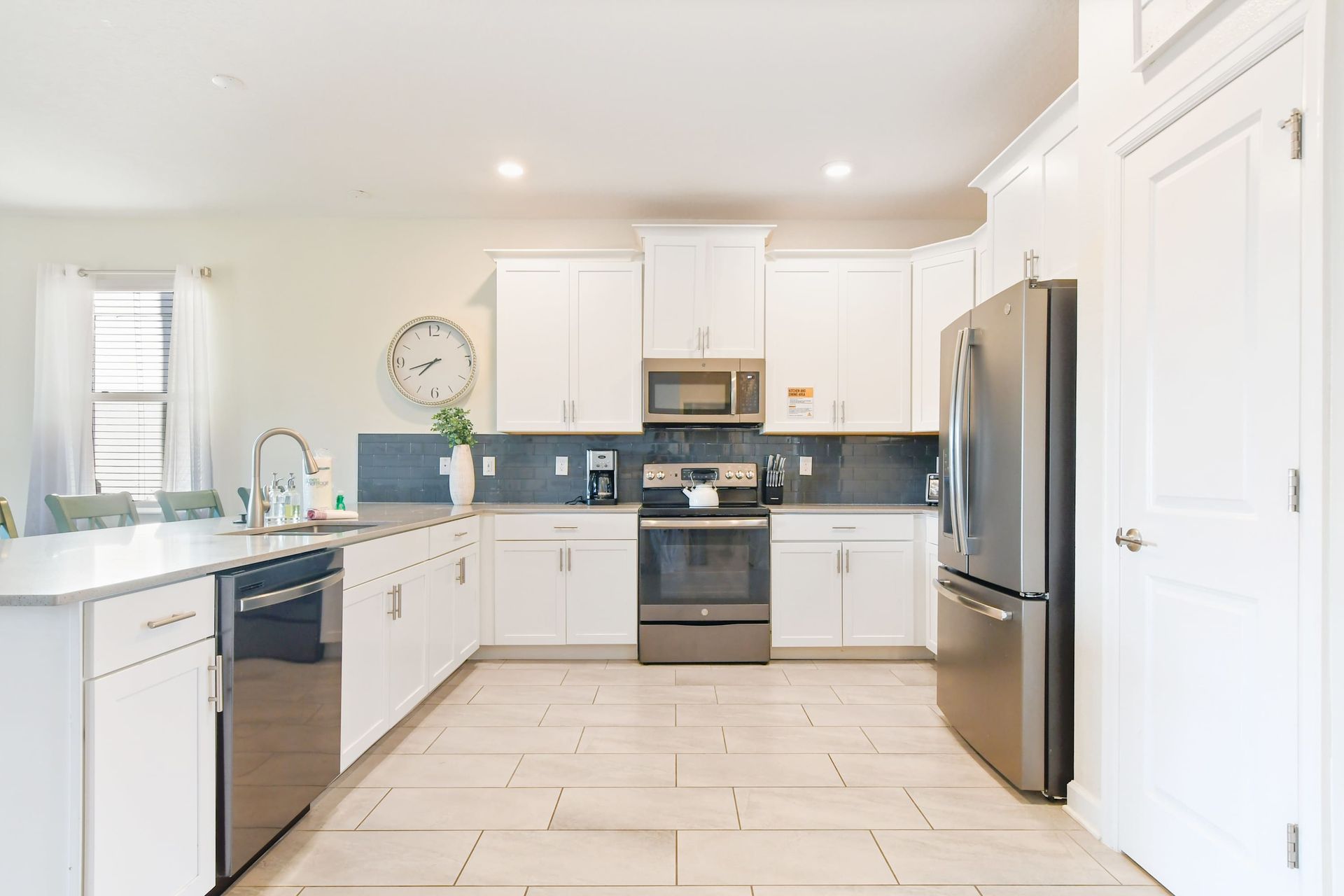 Modern fully equipped kitchen with sleek appliances, spacious counters, and bright decor