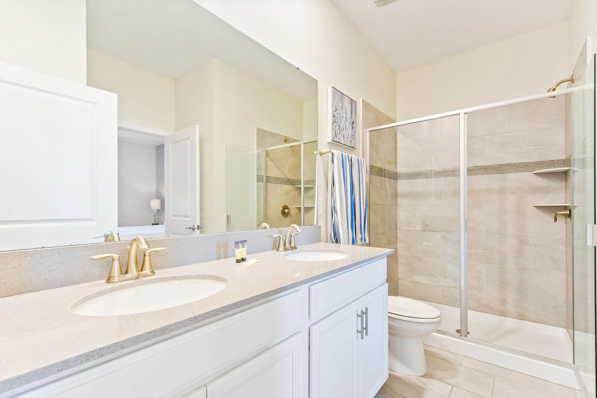 Modern bathroom with a dual vanity, glass walk-in shower, and elegant finishes