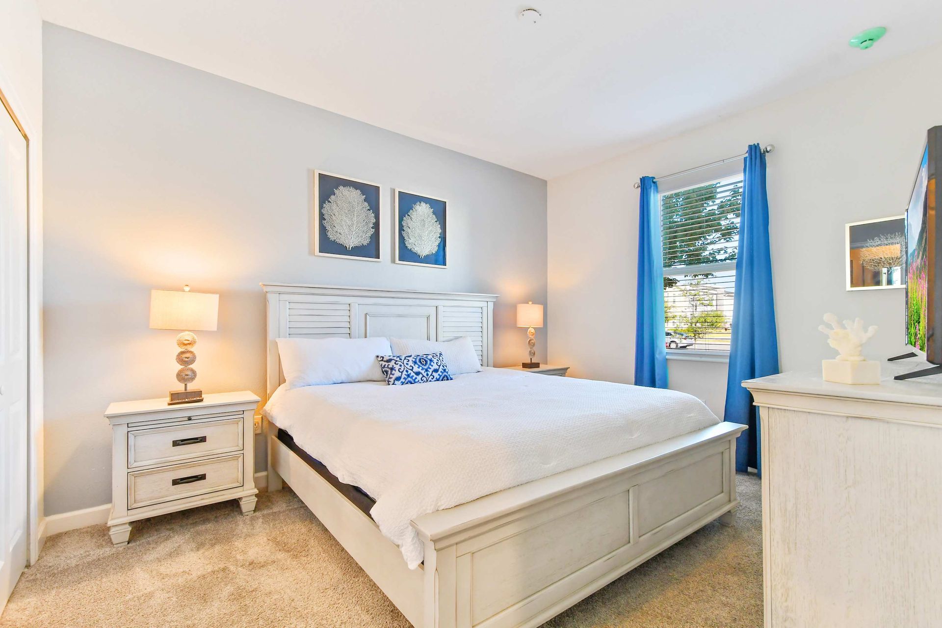Serene coastal-style bedroom with a king bed, elegant decor, and calming blue accents
