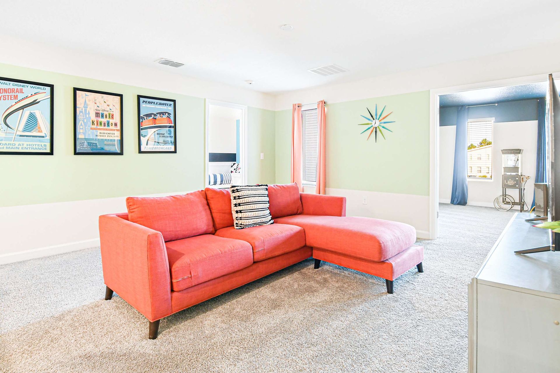 Vibrant loft with a cozy sectional, retro decor, and an attached movie room