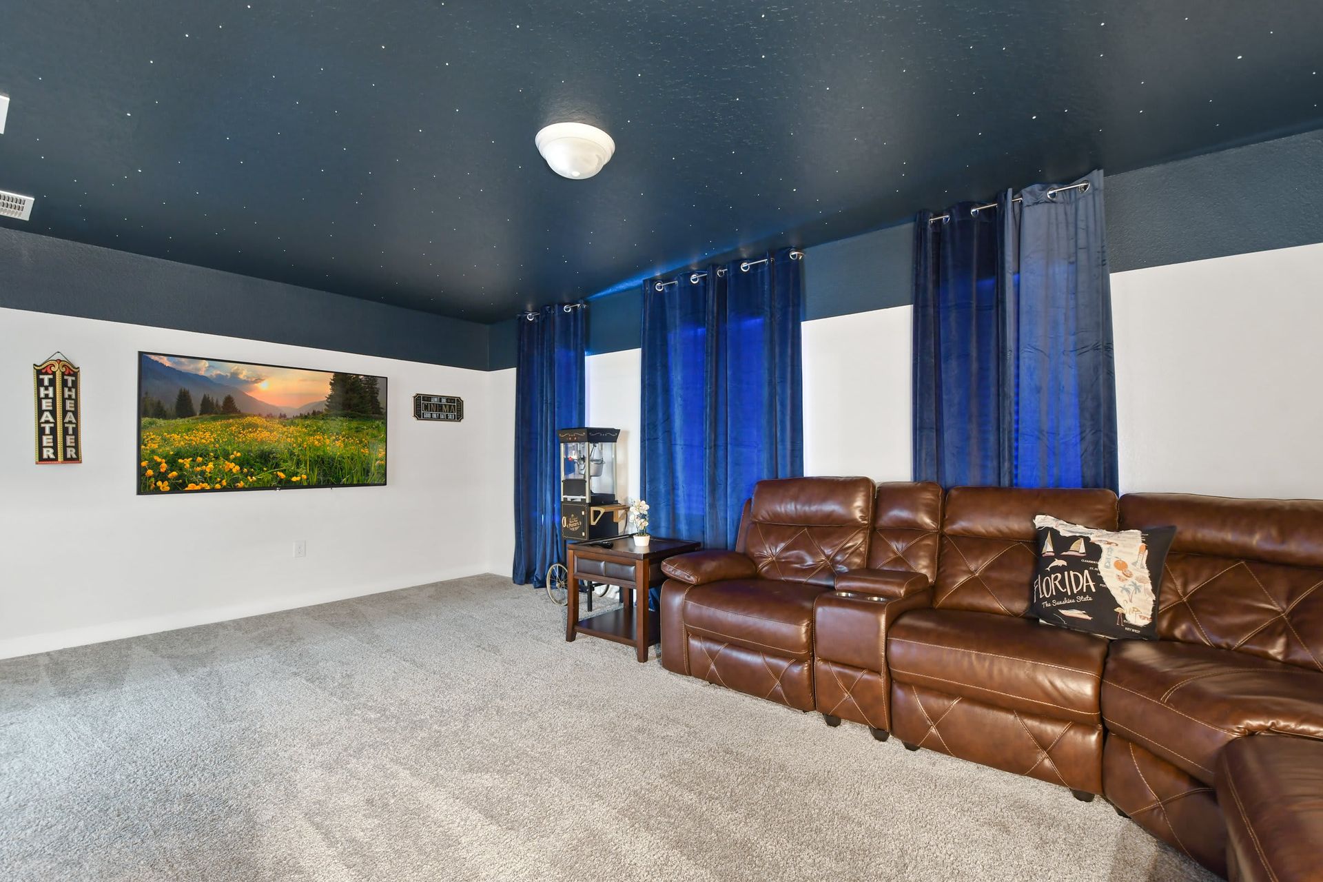 Luxury home theater with reclining seats, starry ceiling, and a cozy cinema vibe