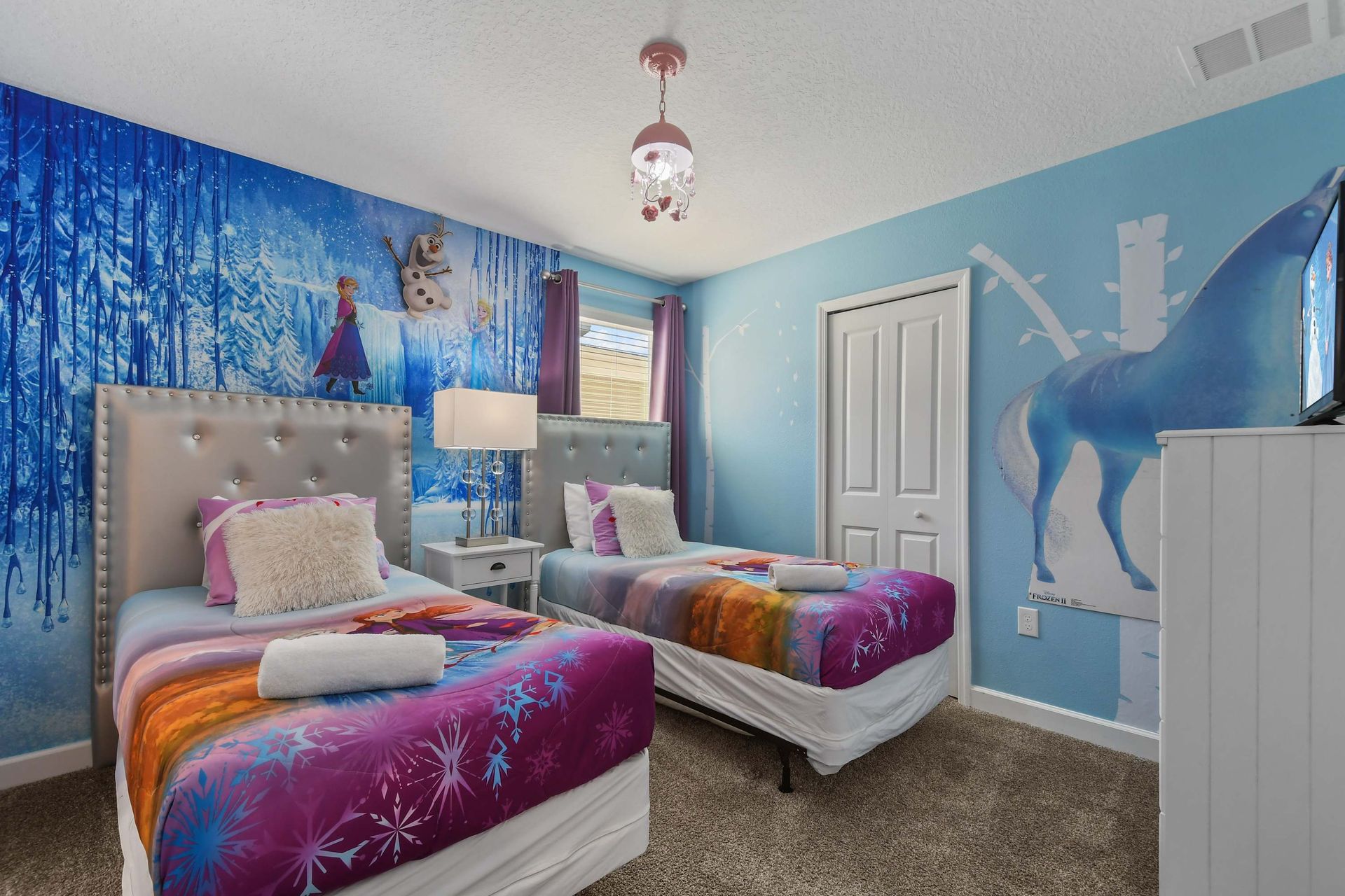 Whimsical ice-themed bedroom with twin beds, plush decor, and a magical winter vibe.