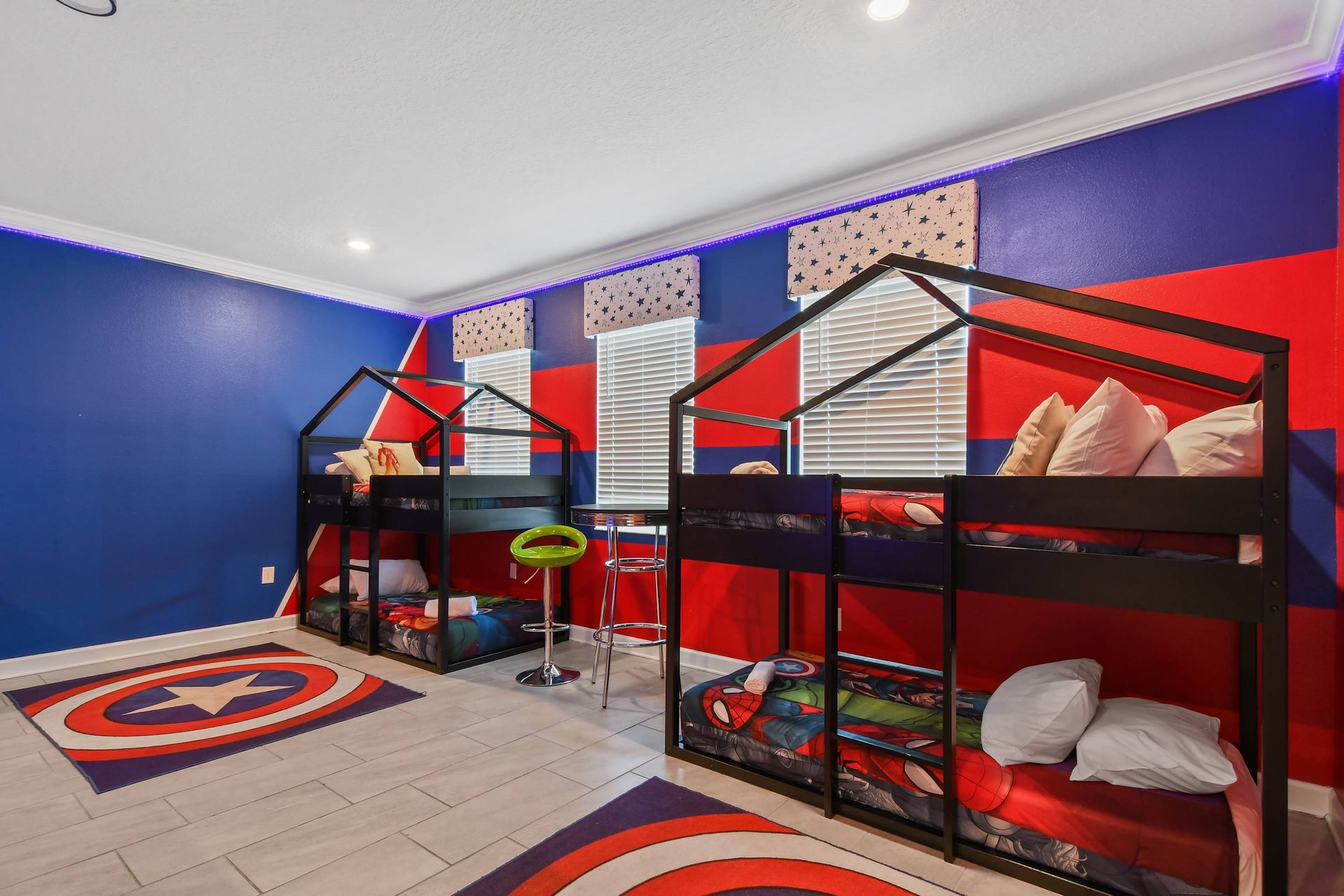 Superhero-themed game room with bunk beds, a pool table, and vibrant decor.