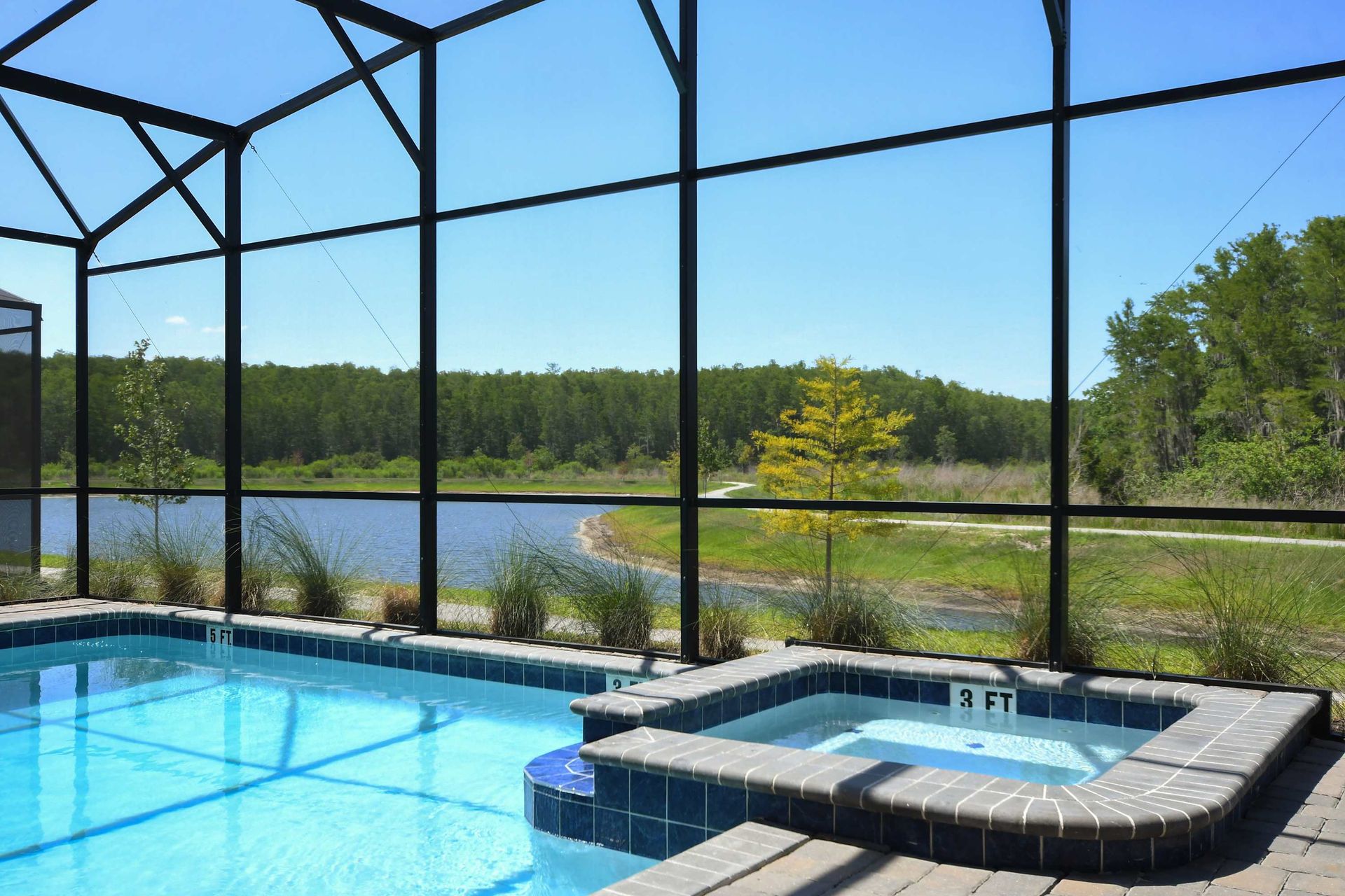 Screened-in private pool with a spa, lounge chairs, and a shaded seating area